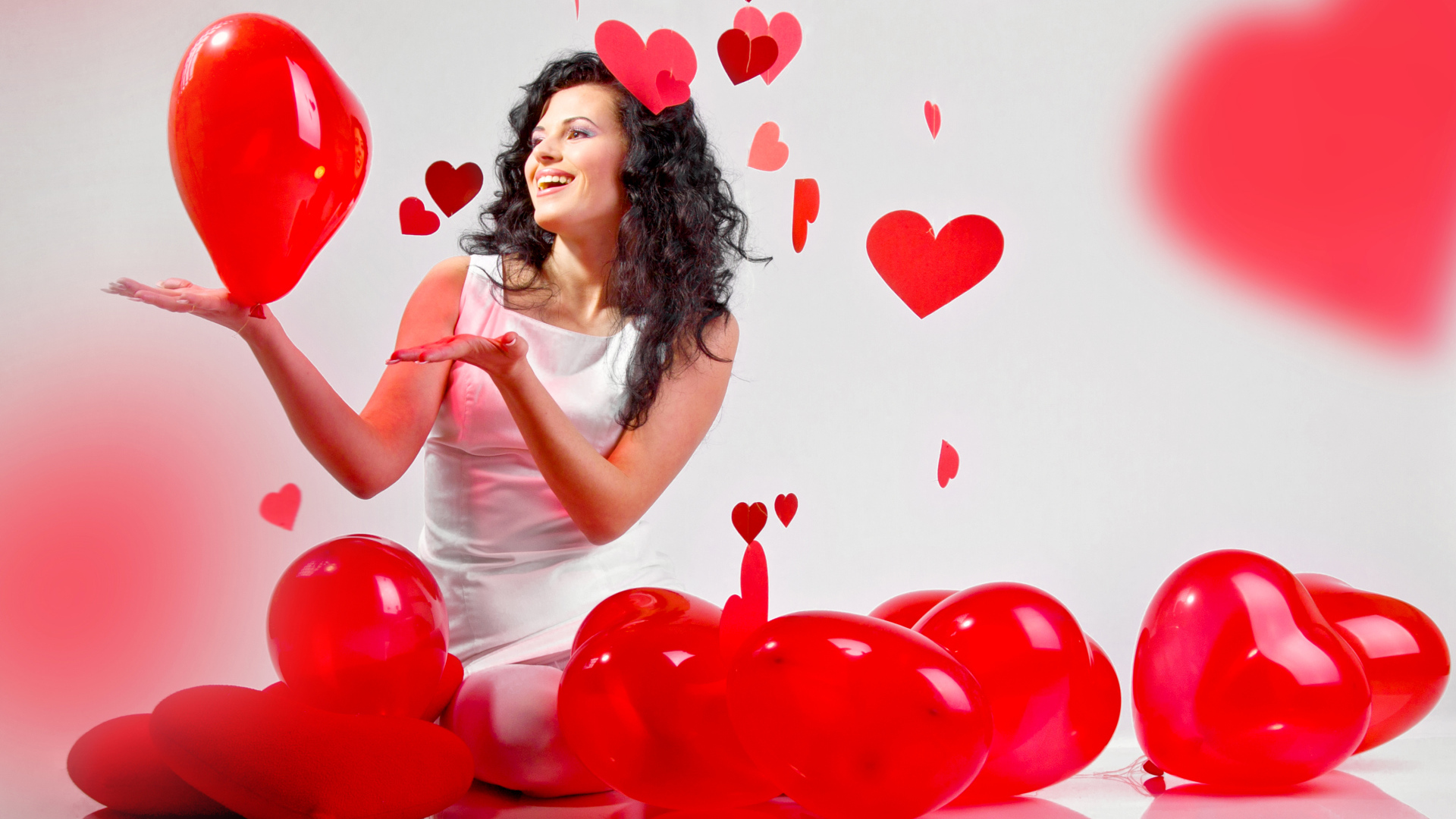 Красивая девушка брюнетка с воздушными шарами в форме сердца