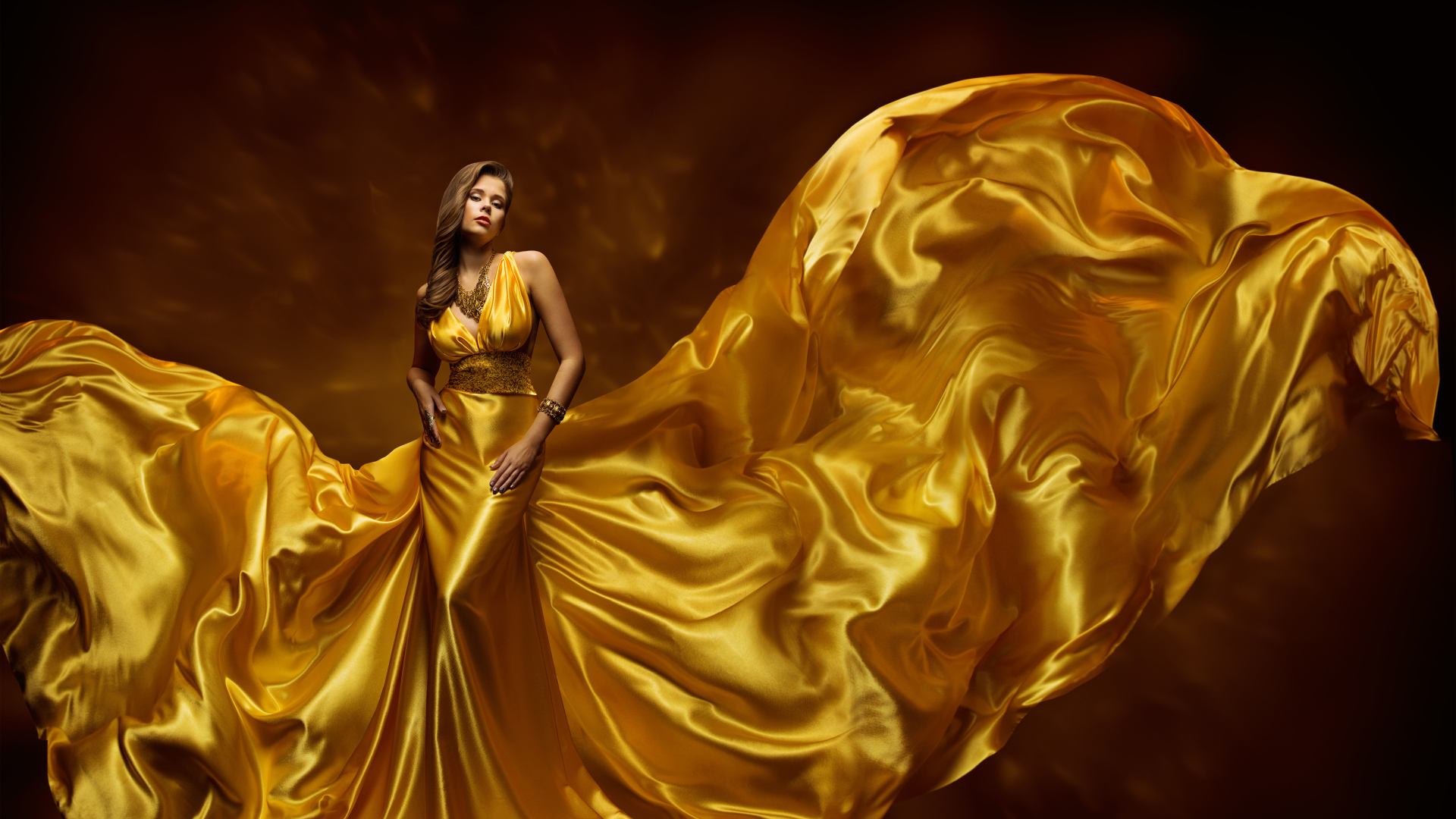 Красивая девушка шатенка в красивом платье золотого цвета