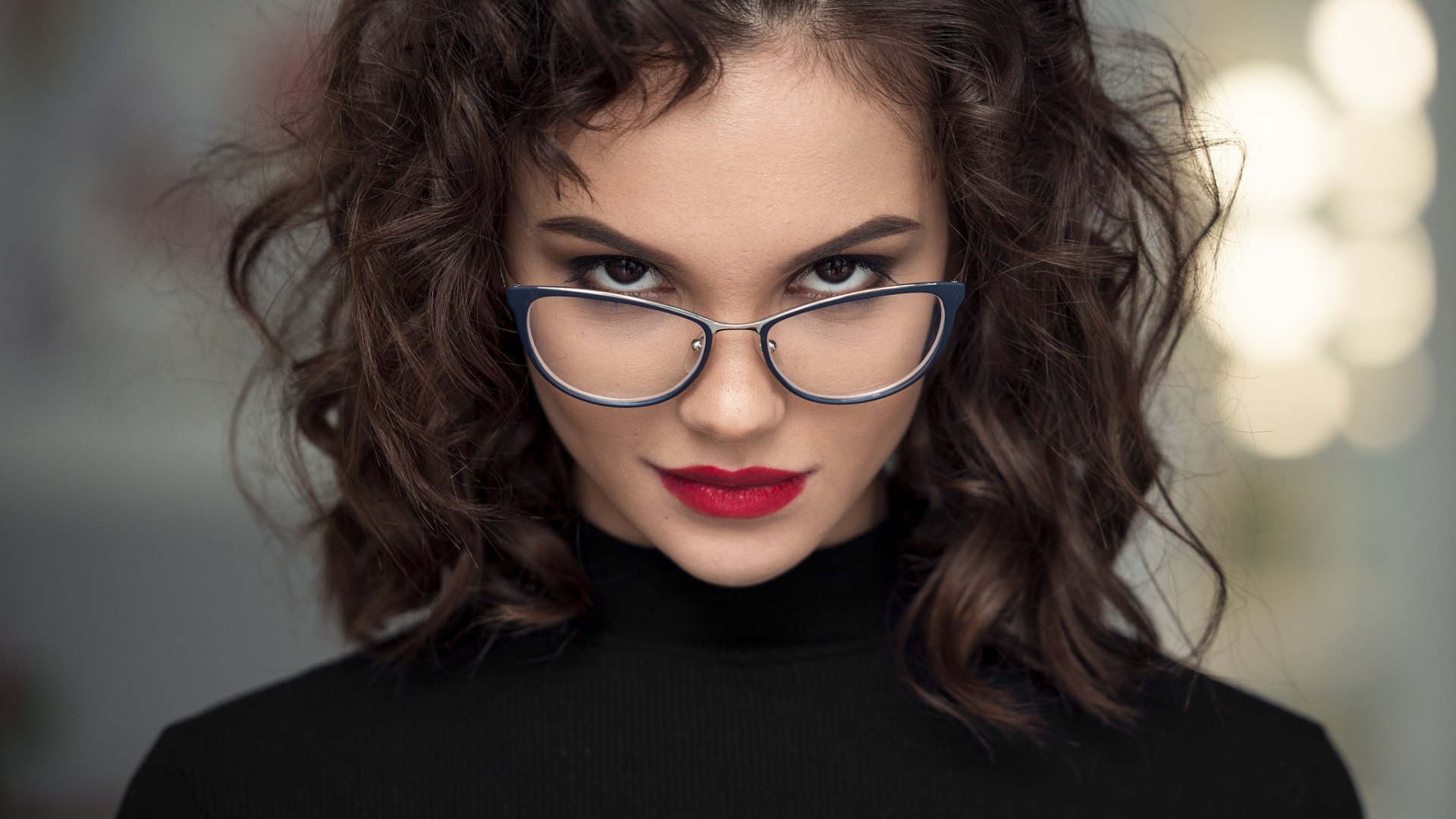 Брюнетка с красными губами с очками на лице