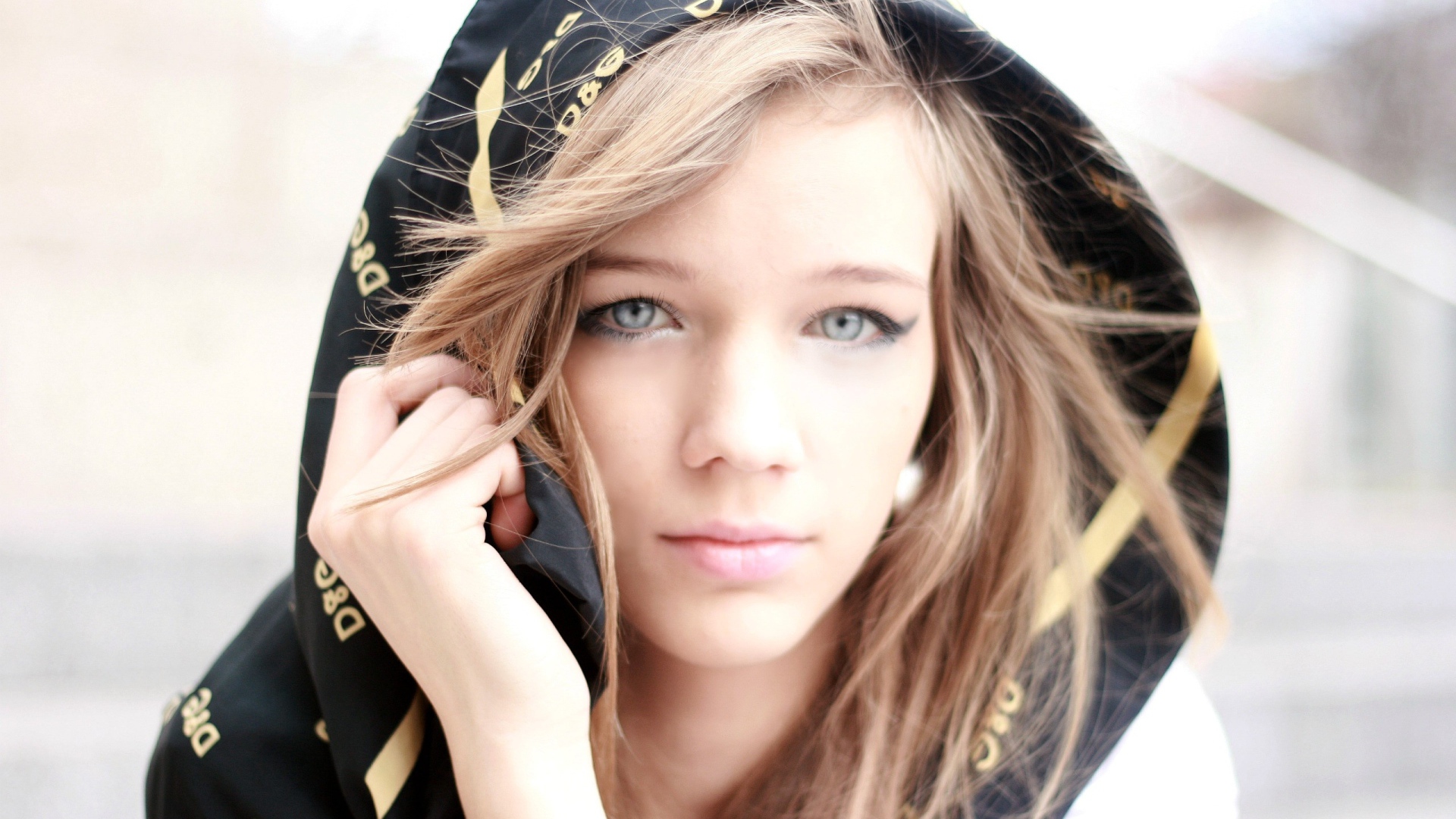 Девушка с голубыми глазами с капюшоном на голове