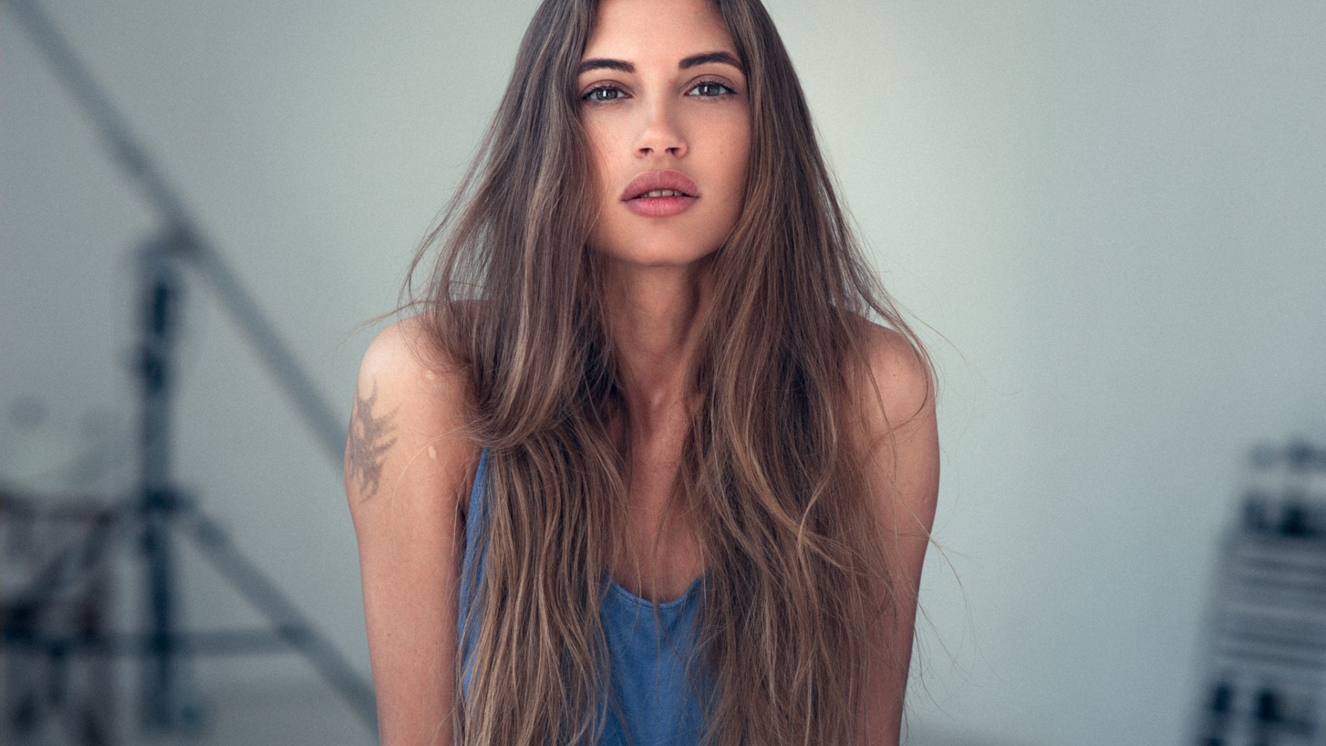 Девушка с длинными волосами и татуировкой на плече 