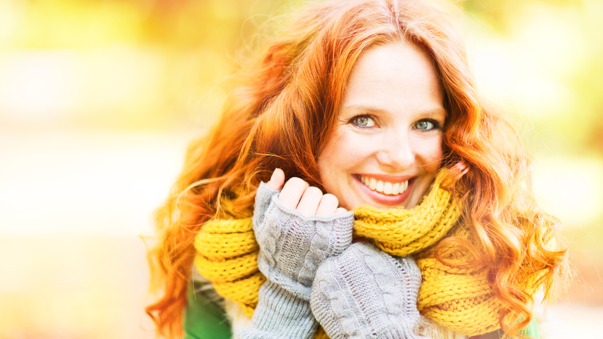 Улыбающаяся рыжеволосая девушка в теплом шарфе