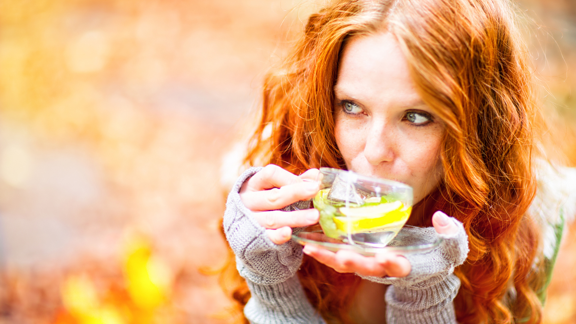 Рыжеволосая девушка модель с чашкой зеленого чая 