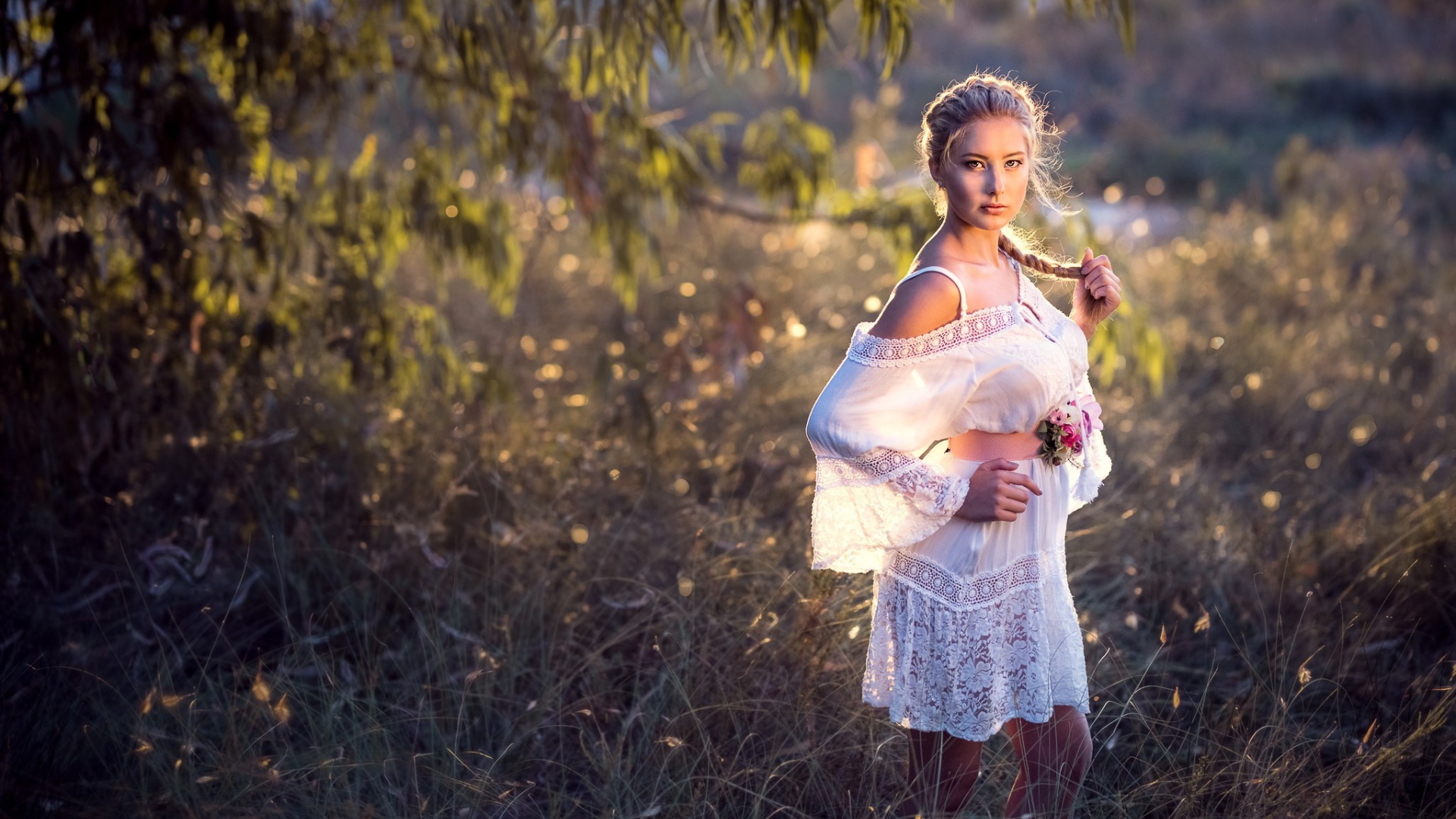 Молодая девушка модель в красивом белом платье с косой на голове