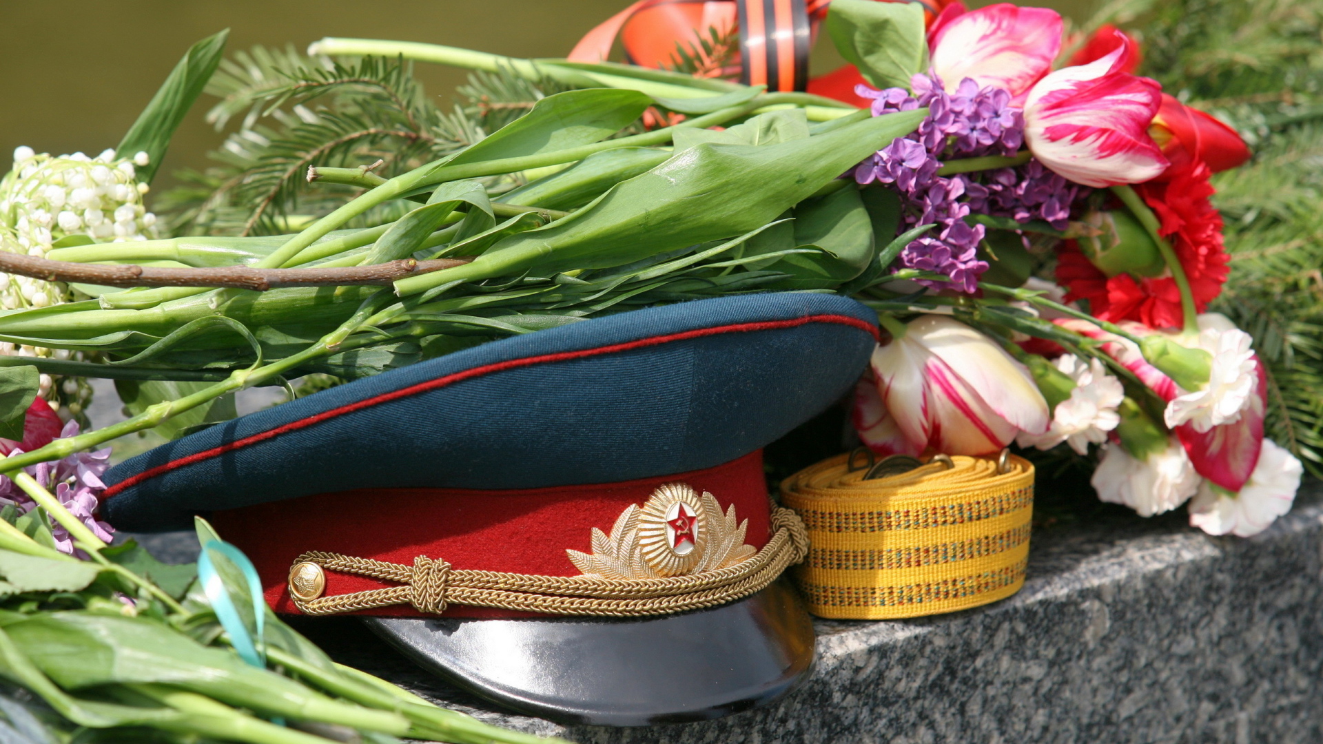Военная фуражка и цветы на День Победы 9 мая 