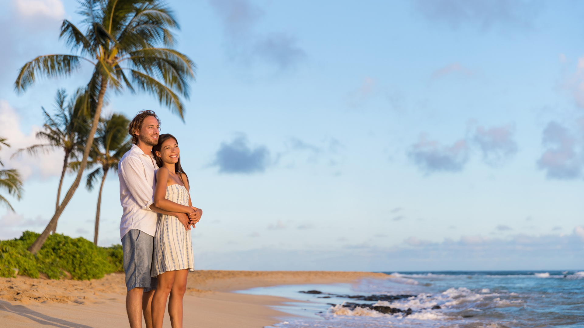 Влюбленная пара встречает закат на берегу океана