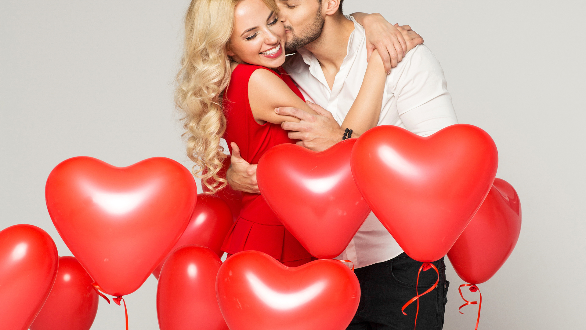 Счастливая влюбленная пара с воздушными шариками в форме сердца