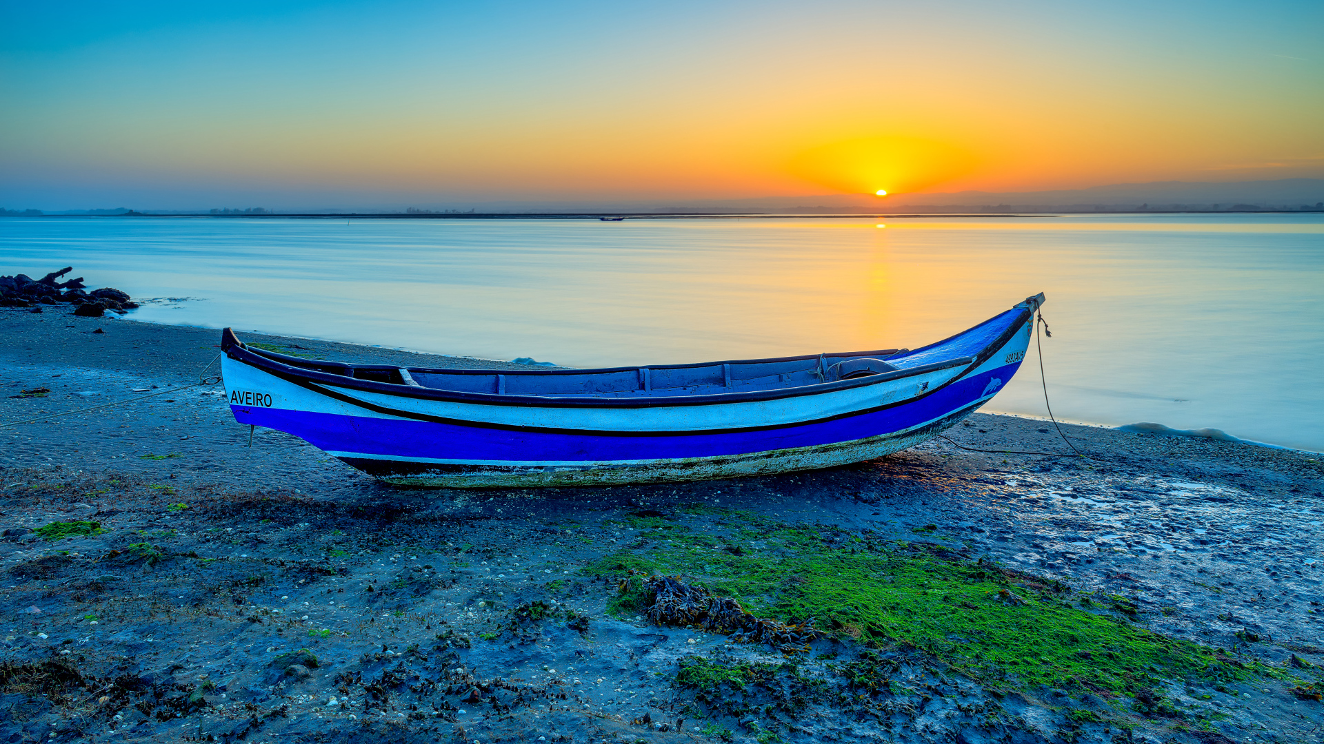 Лодка на берегу реки на закате солнца