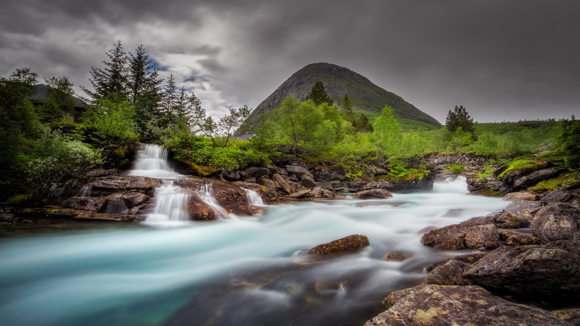 Быстрая вода в горной реке с маленьким водопадом 
