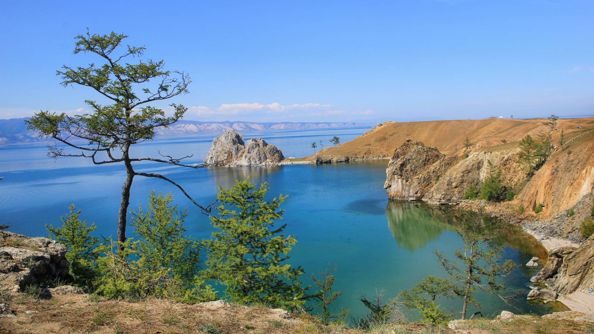 Каменные утесы у чистой воды живописного озера Байкал,  Россия