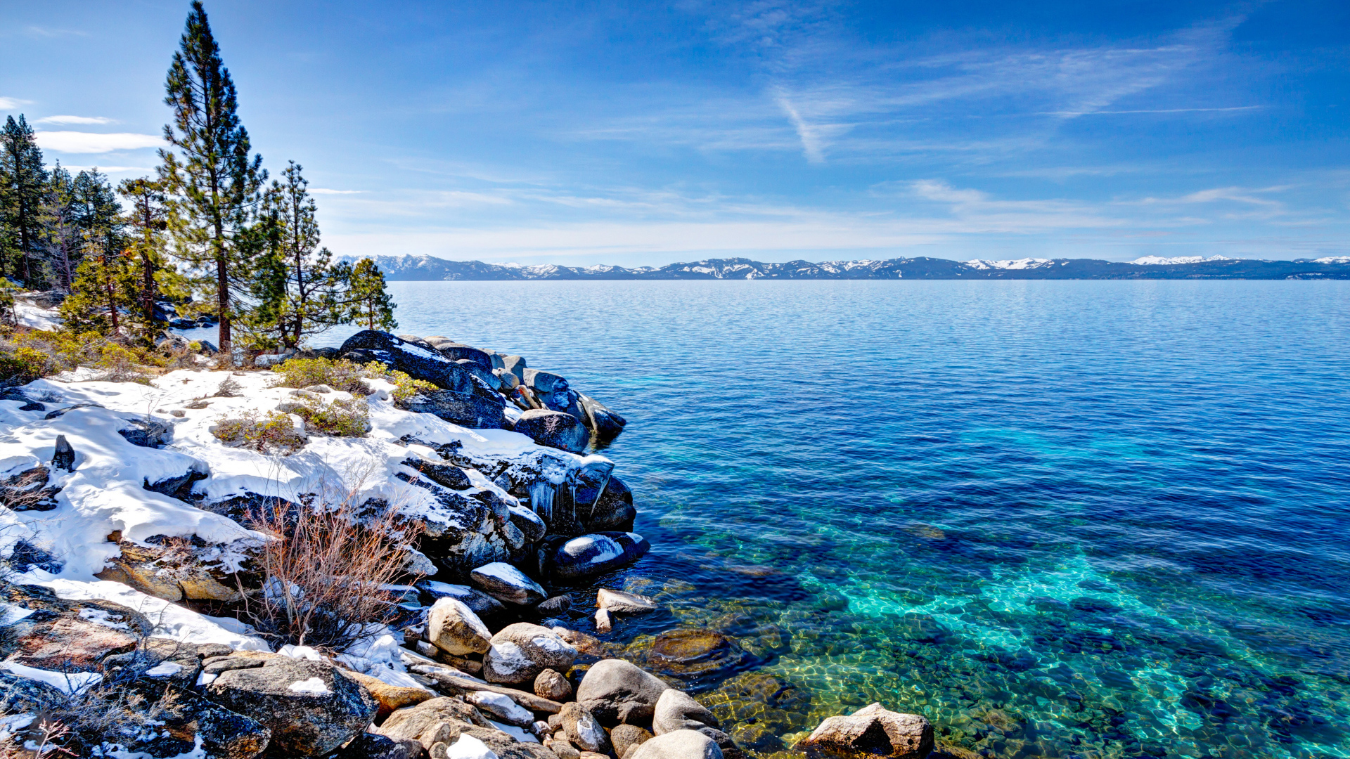Чистая вода в озере Тахо с покрытыми снегом берегами, США