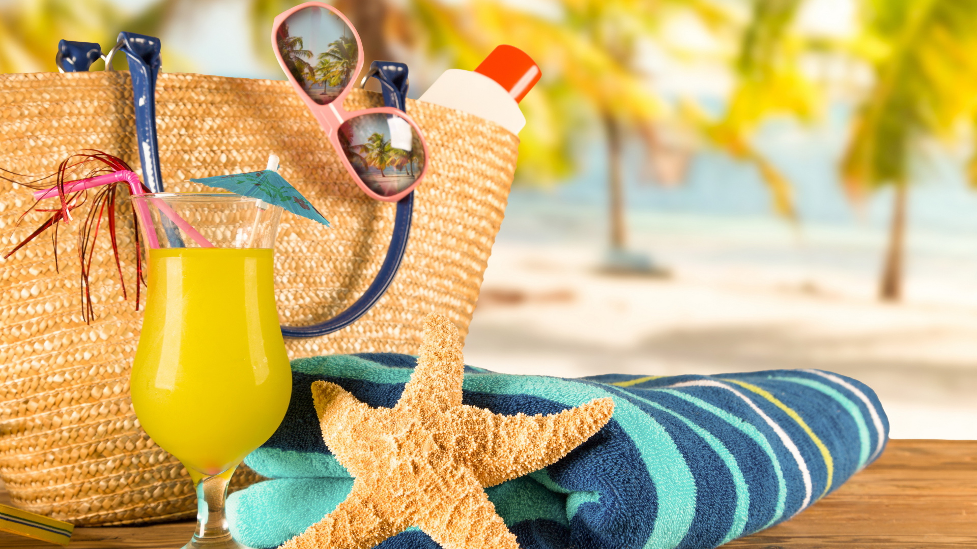 Beach bag with glasses, towel, cocktail and starfish
