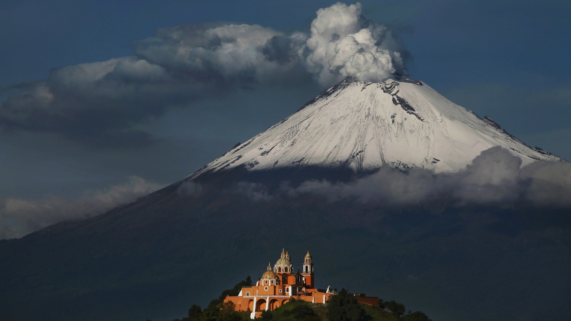 Дымящаяся вершина вулкана Попокатепетль в лучах солнца 