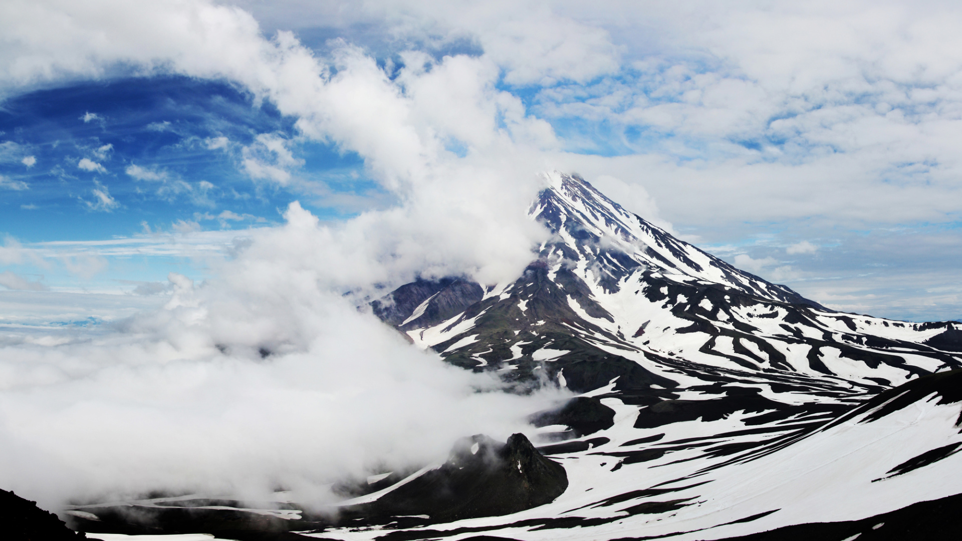 Вулкан Авачинская сопка покрыт белыми облаками, Камчатка. Россия 