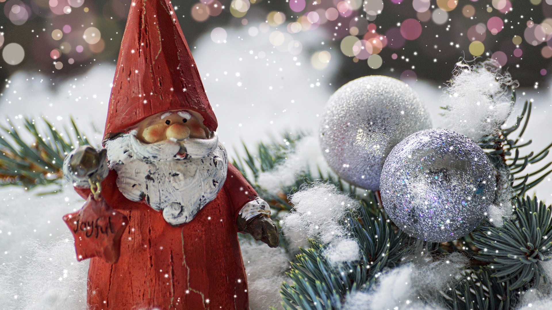 Статуэтка деда Мороза рядом с еловой веткой и яркими шарами