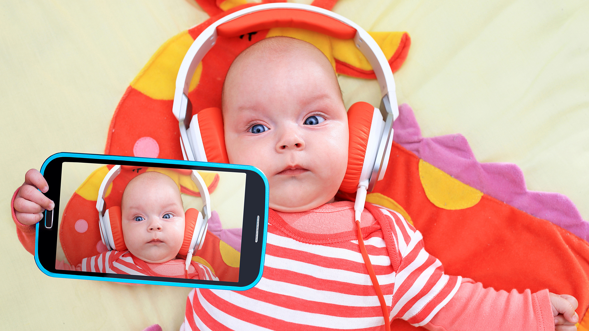 Младенец в оранжевых наушниках делает селфи