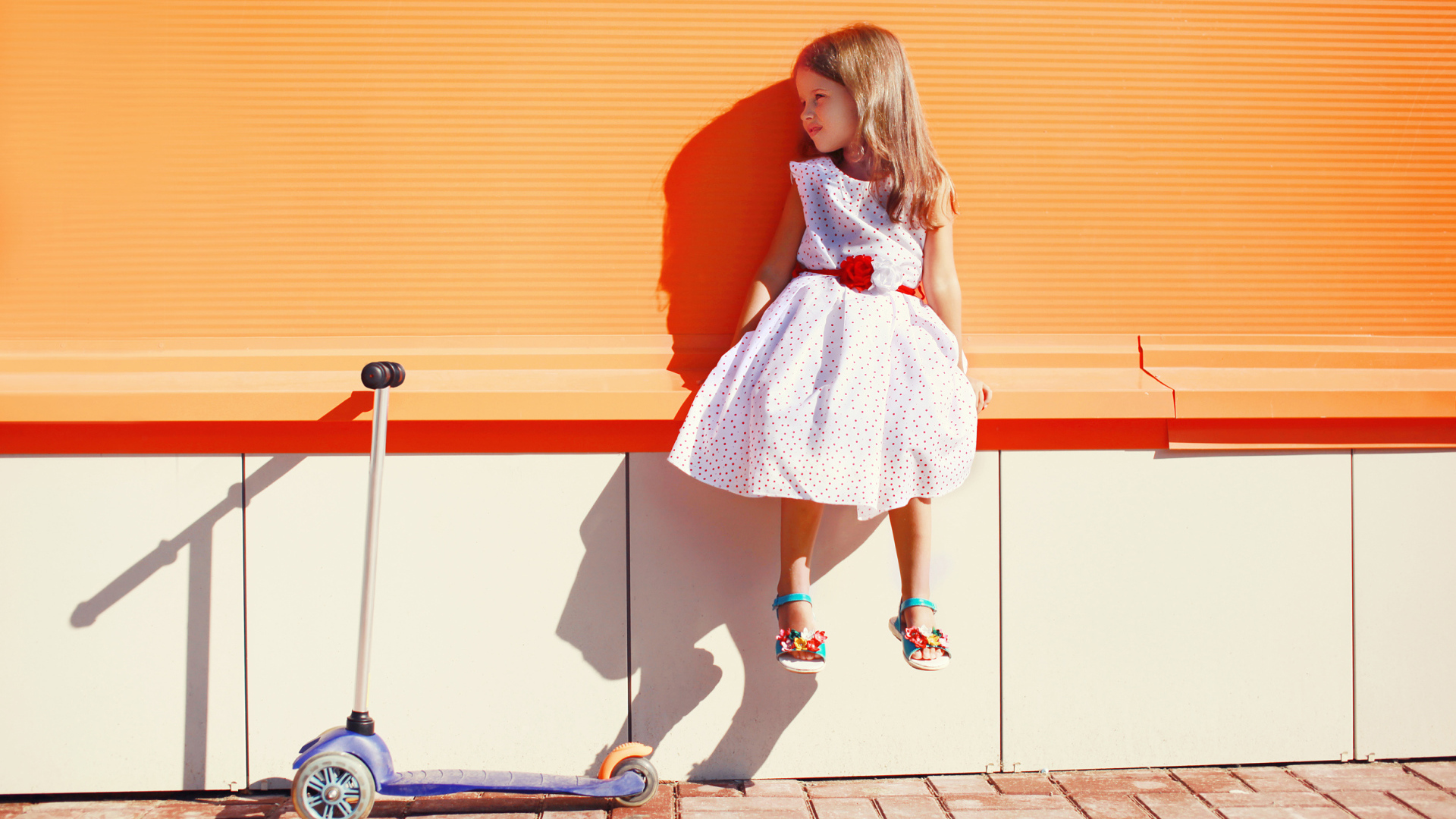 Девочка в красивом платье с самокатом
