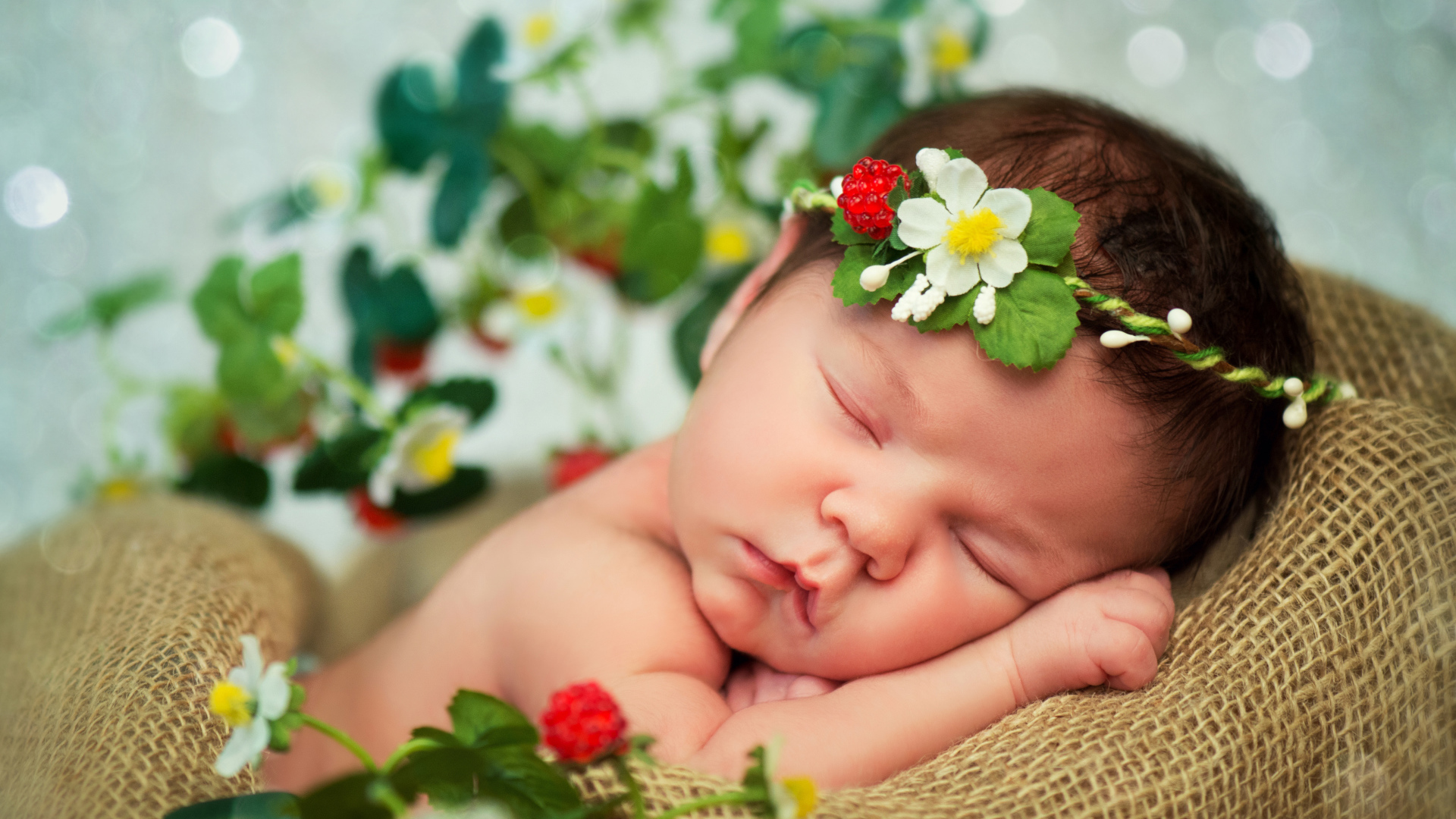 Спящий грудной ребенок с красивой повязкой на голове