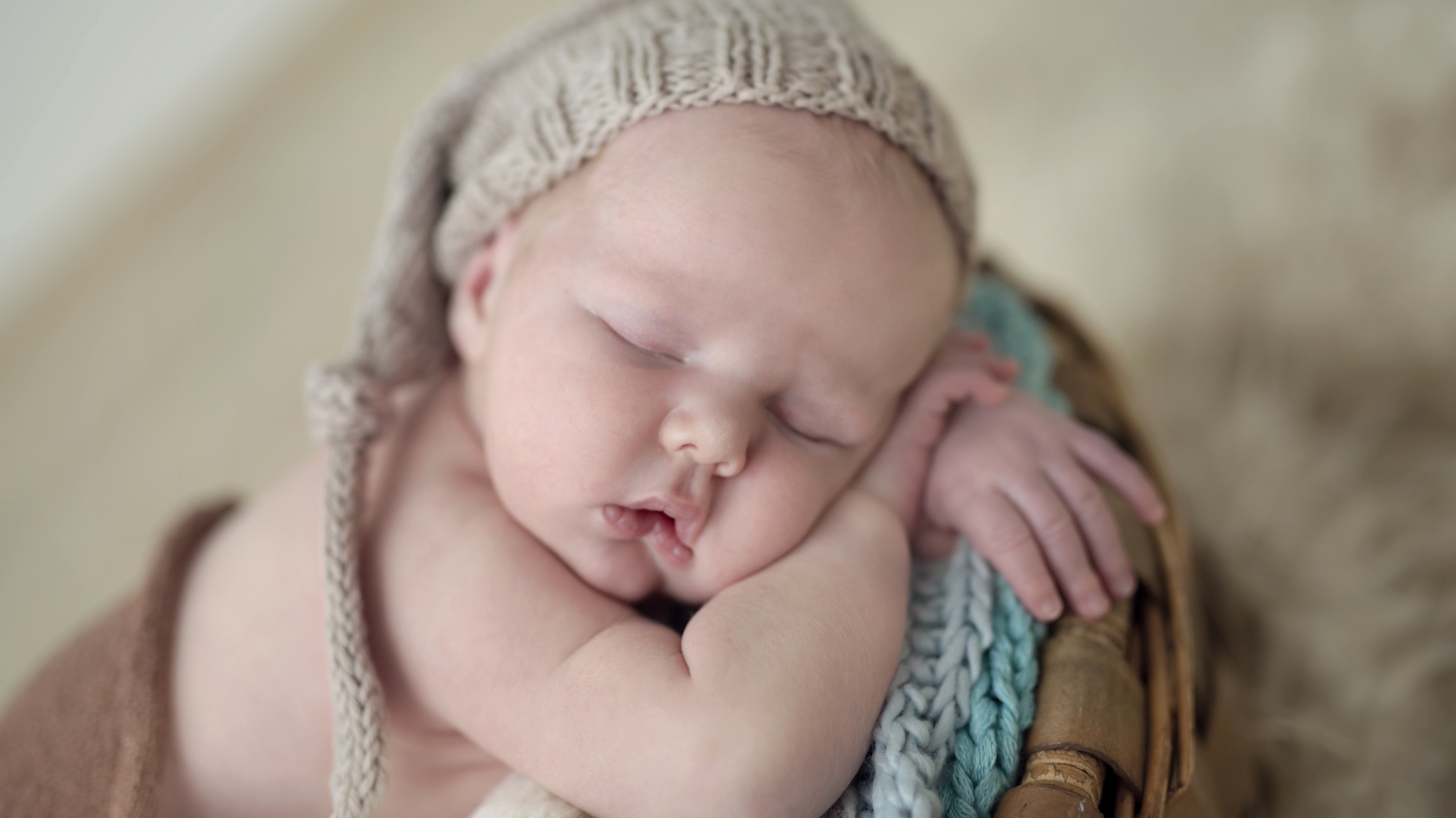 Маленький грудной ребенок спит в вязаной шапке