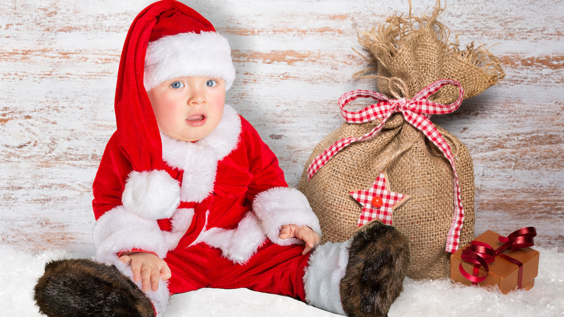 Маленький ребенок в костюме Санты с мешком