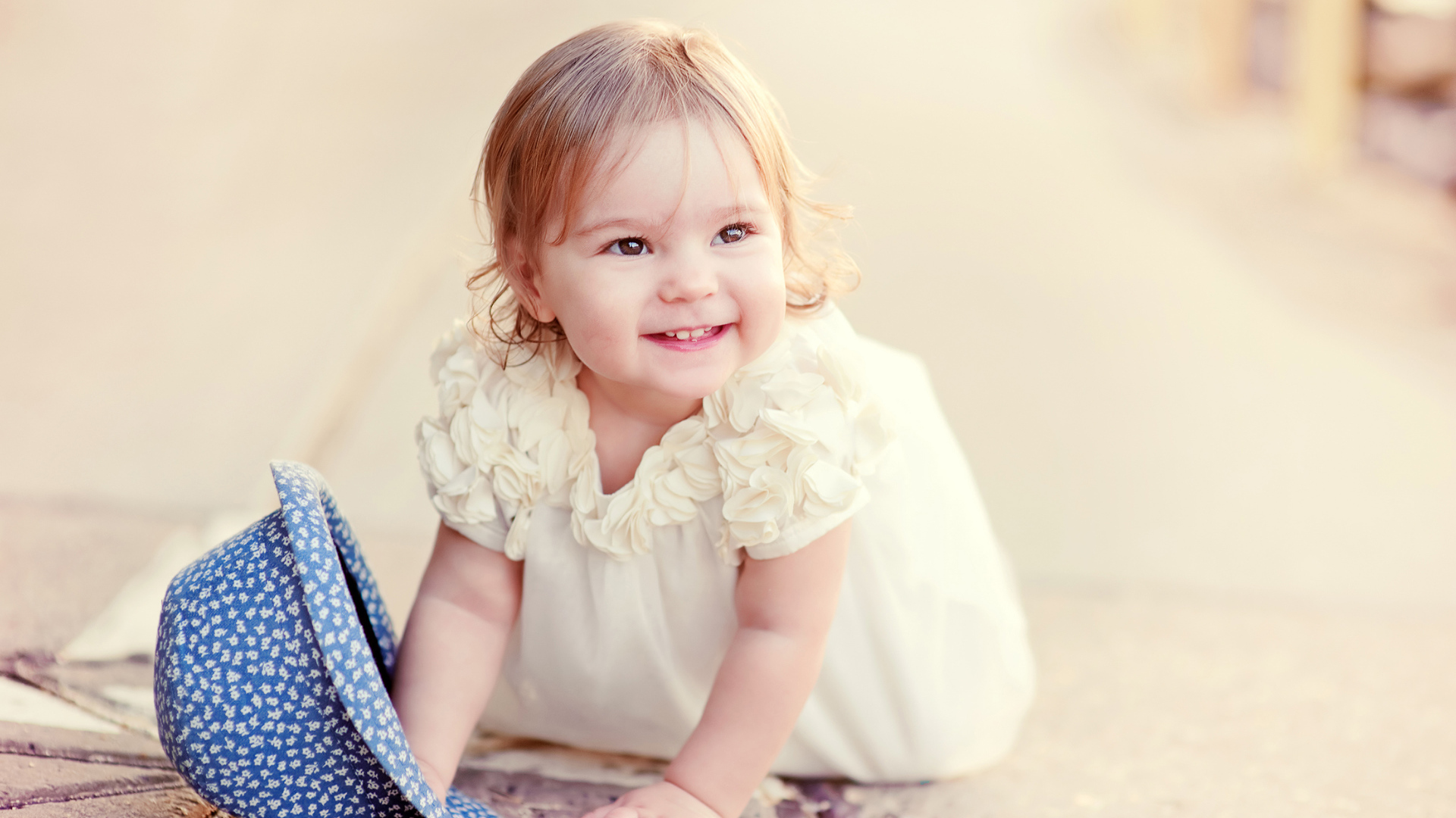 Милая улыбающаяся девочка в белом платье