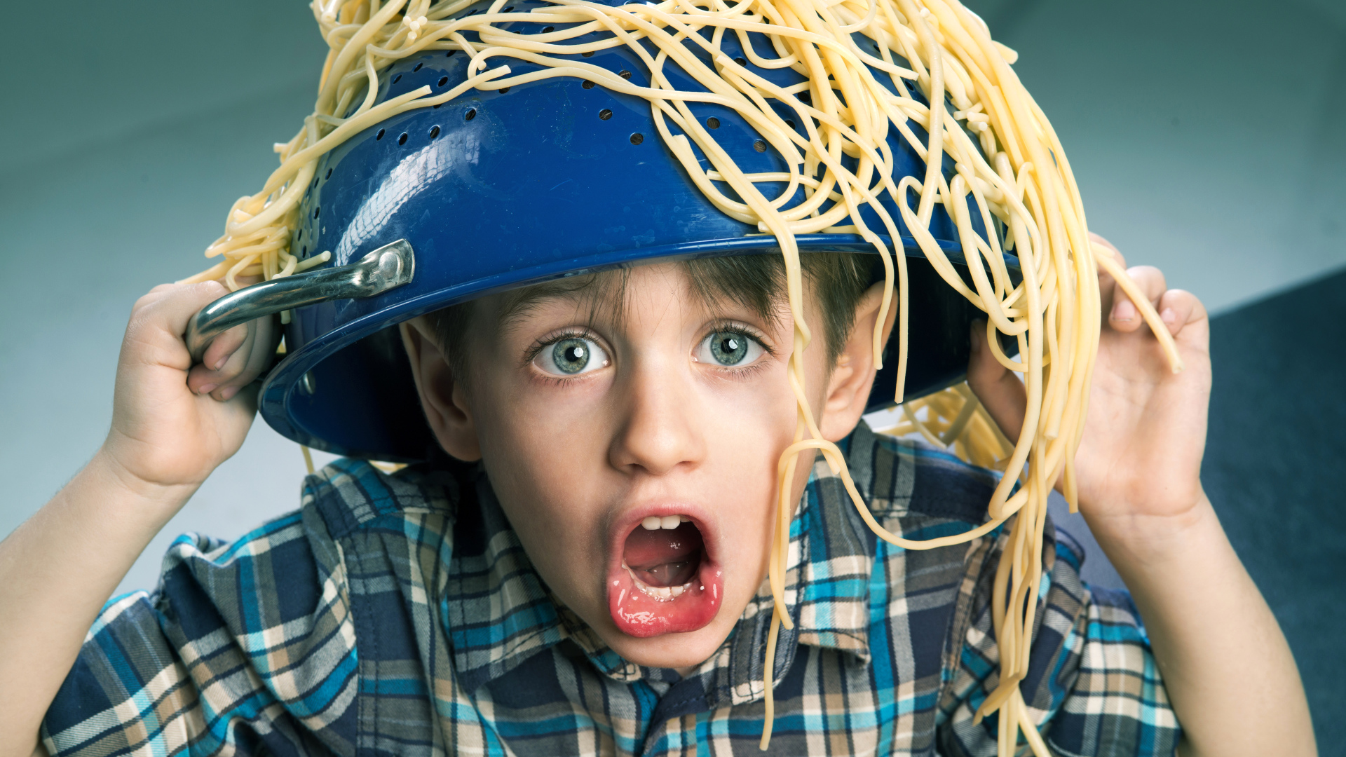 Смешной мальчик со спагетти на голове