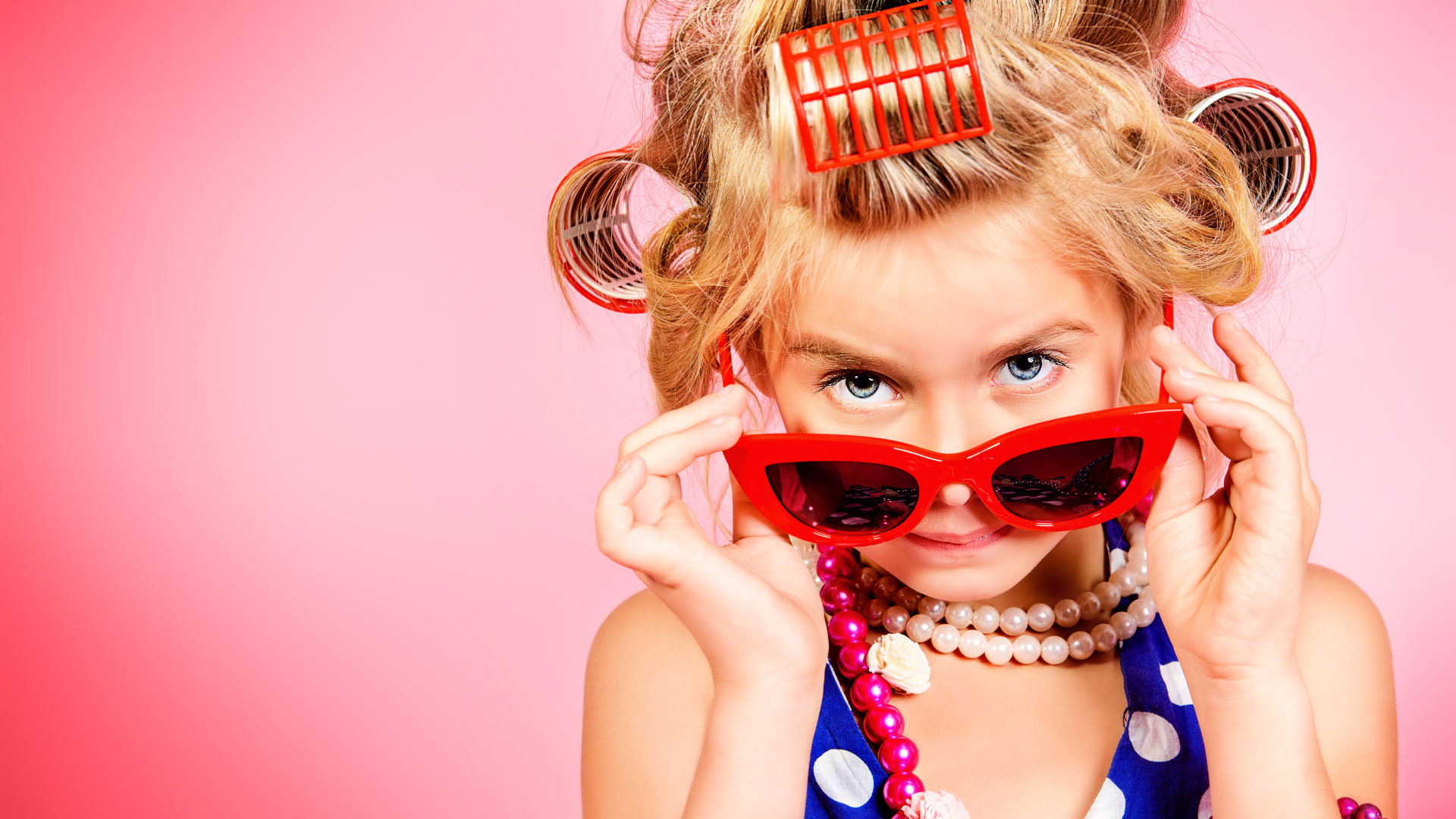 Гламурная девочка в больших красных очках и бигудями на голове