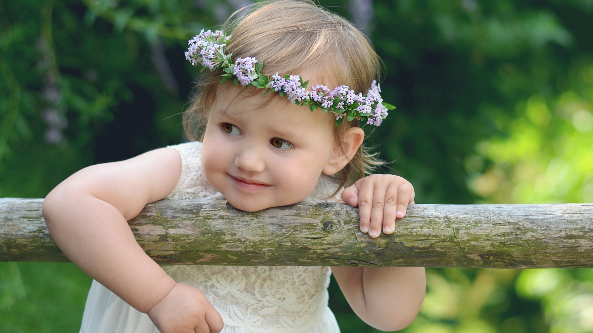 Маленькая кареглазая девочка с венком на голове