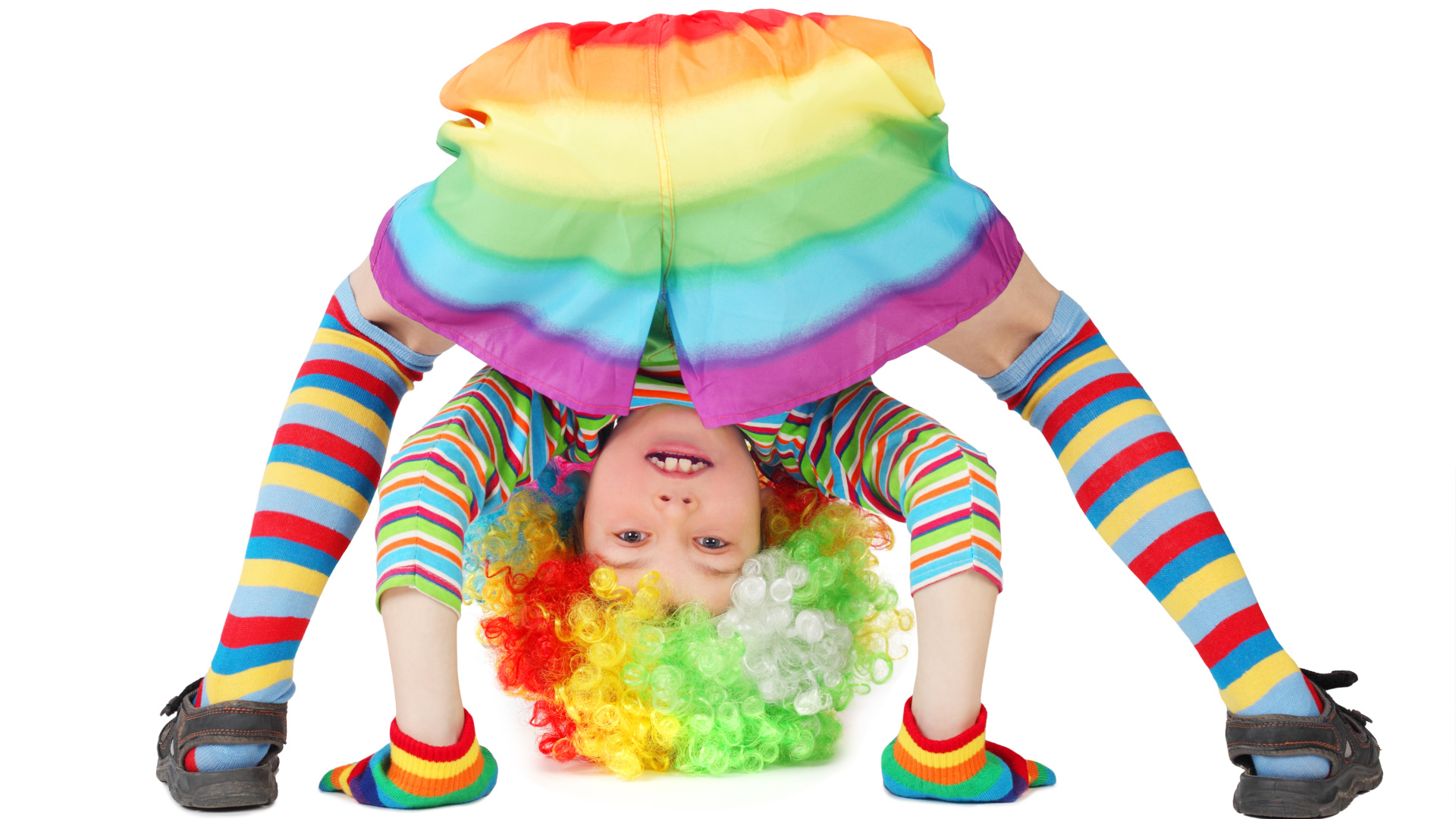 Маленькая смешная девочка в костюме клоуна на белом фоне