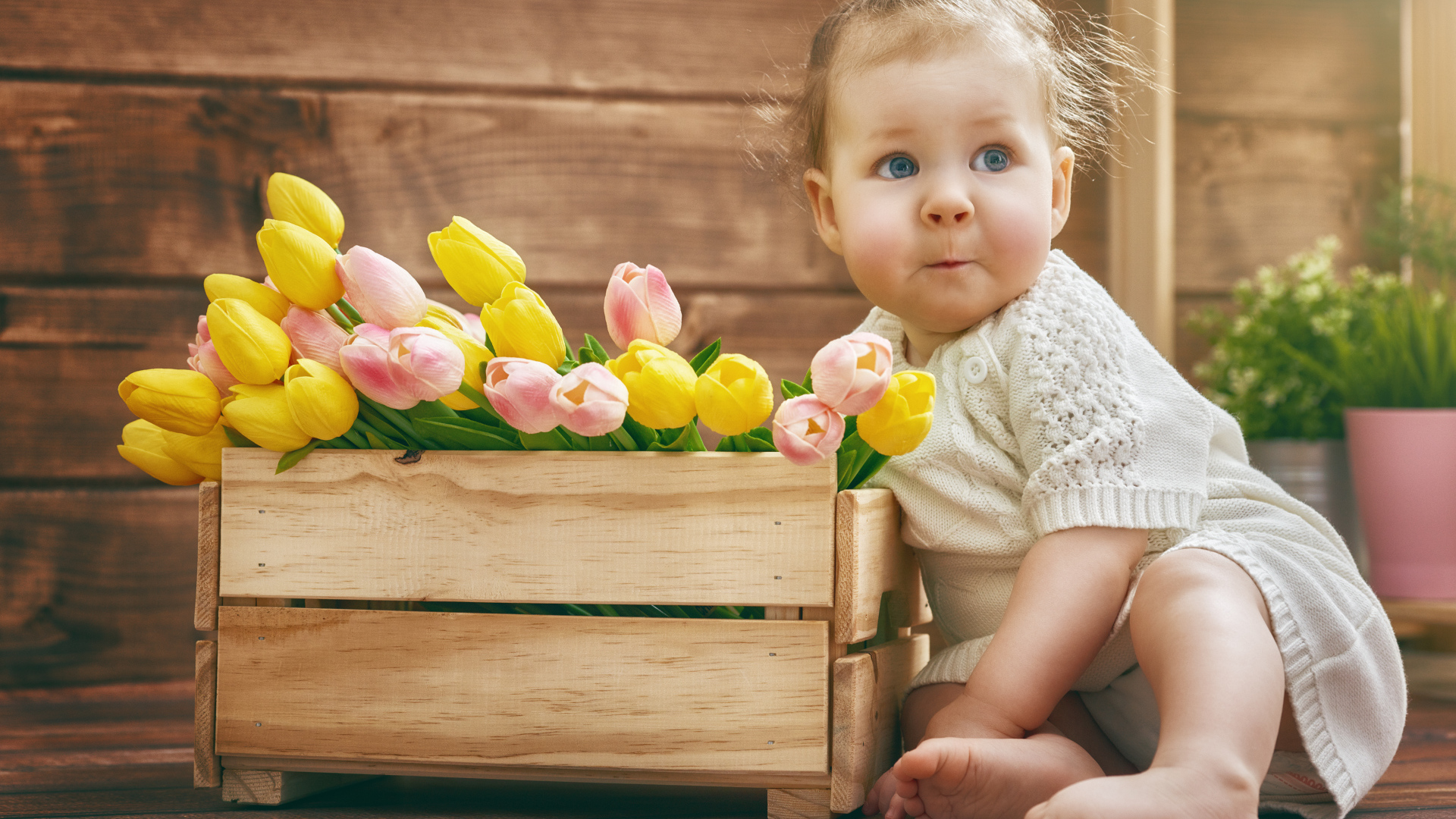 Маленькая забавная девочка с букетом тюльпанов