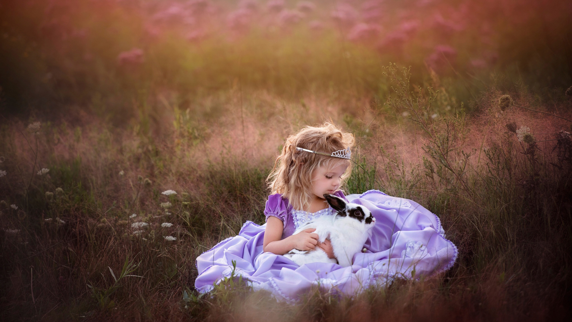 Маленькая девочка в красивом платье с кроликом в руках