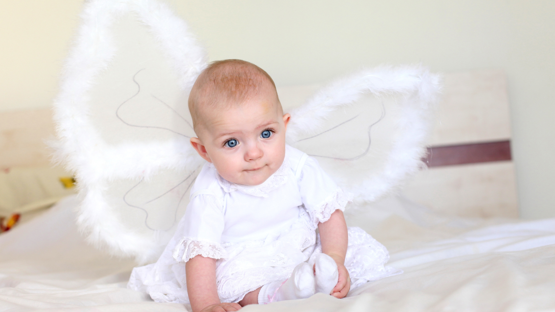 Маленькая девочка в красивом белом платье с крыльями