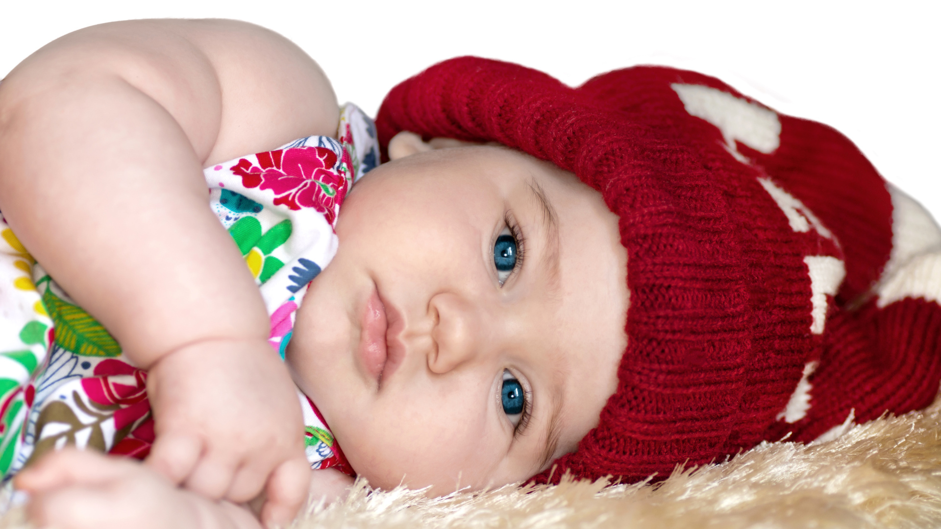 Маленькая девочка в красной вязаной шапке