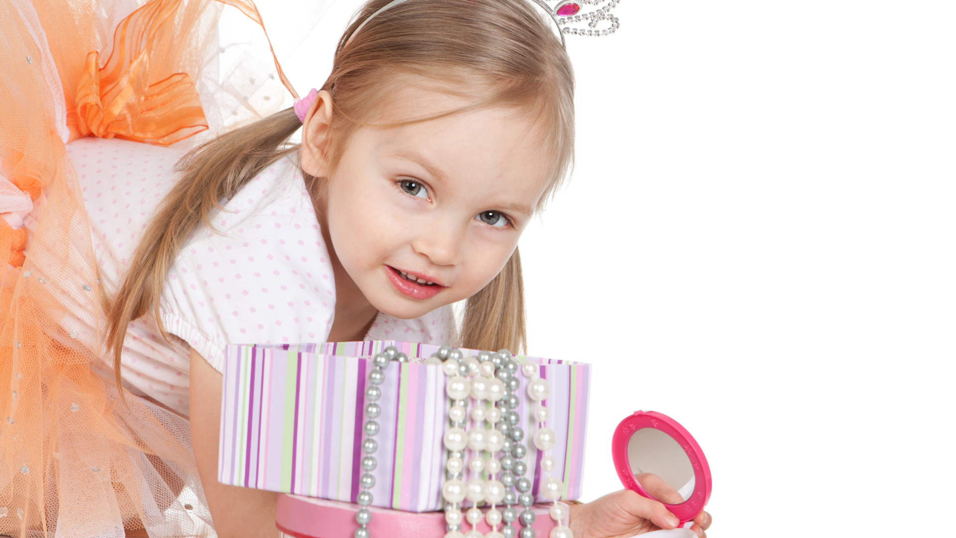 Маленькая девочка в короне на голове и с зеркалом на белом фоне