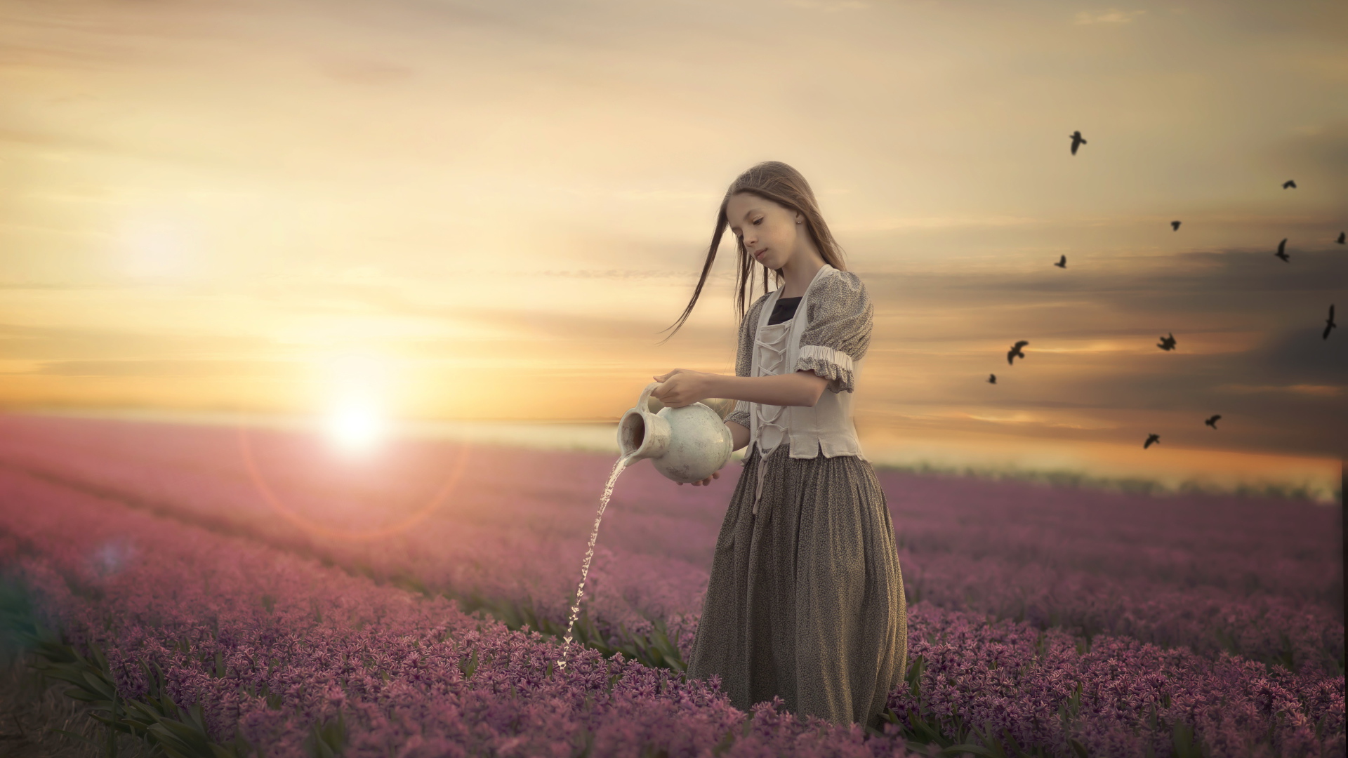 Маленькая девочка поливает цветы из кувшина в поле на закате