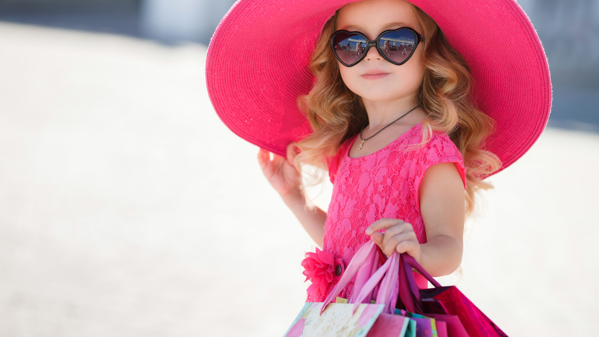 Маленькая девочка модница в большой розовой шляпе