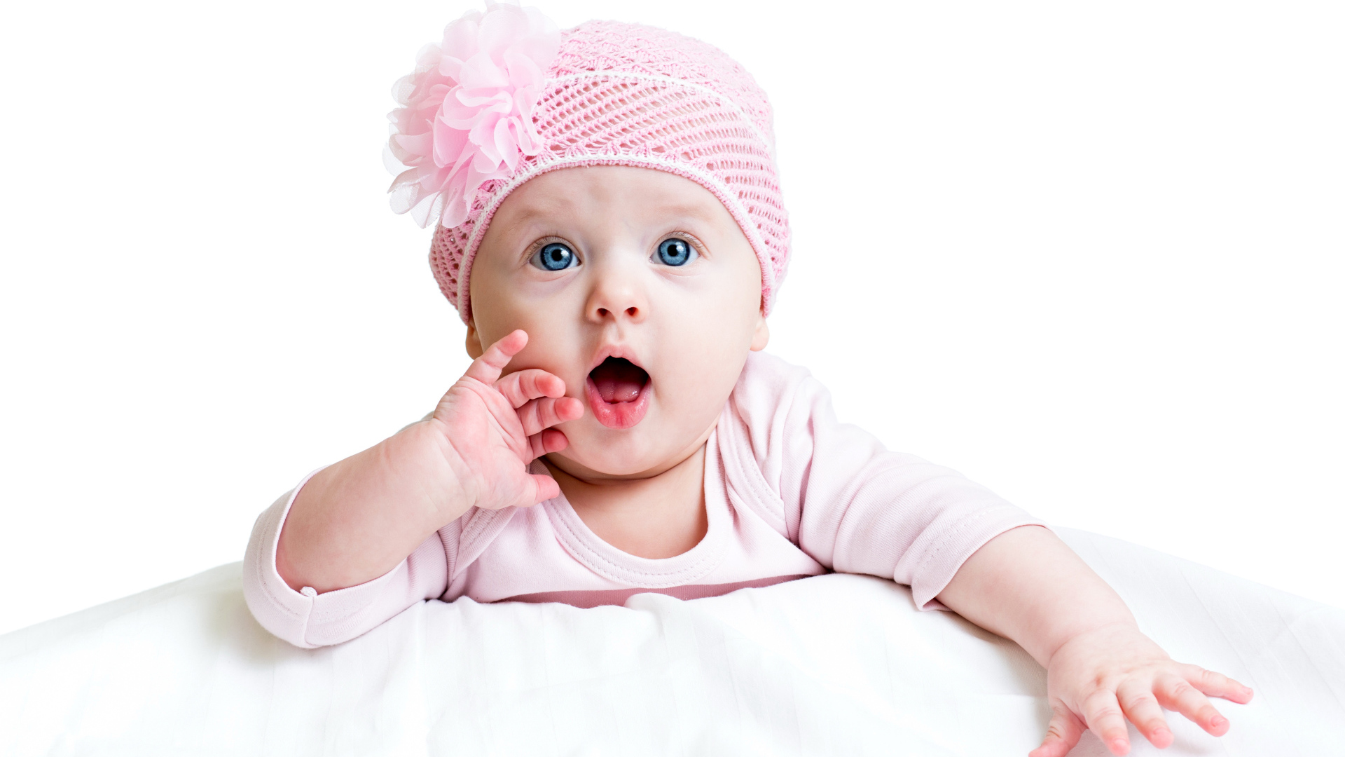 Грудная голубоглазая девочка в розовой шапке на белом фоне