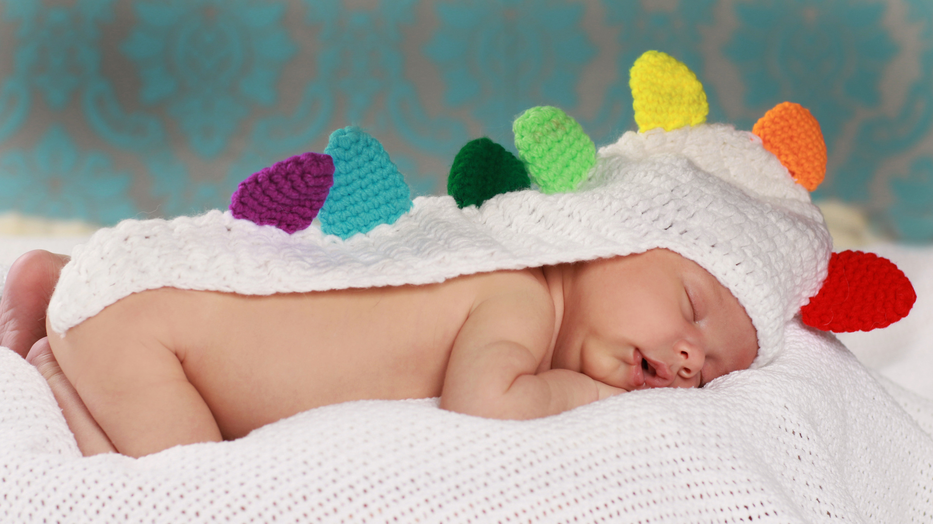 Спящий младенец в белой вязаной накидке