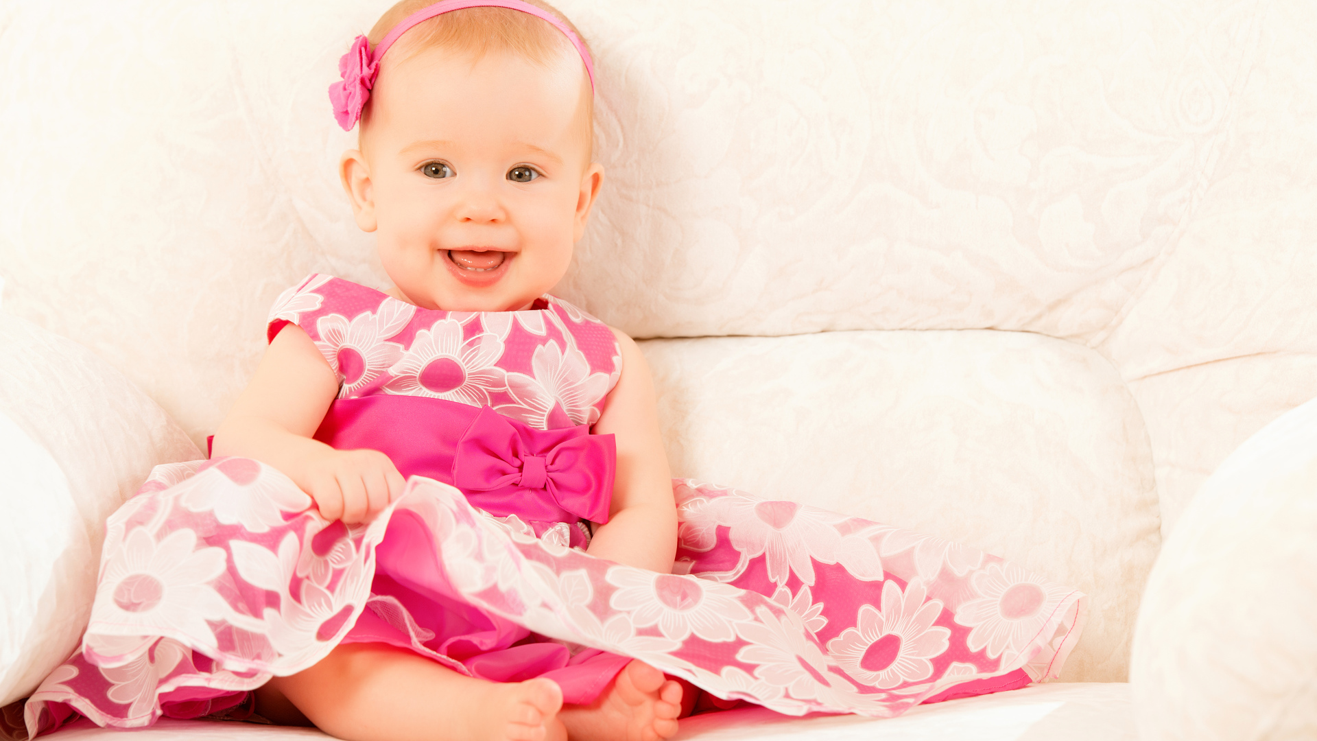 Улыбающаяся маленькая девочка в красивом розовом платье