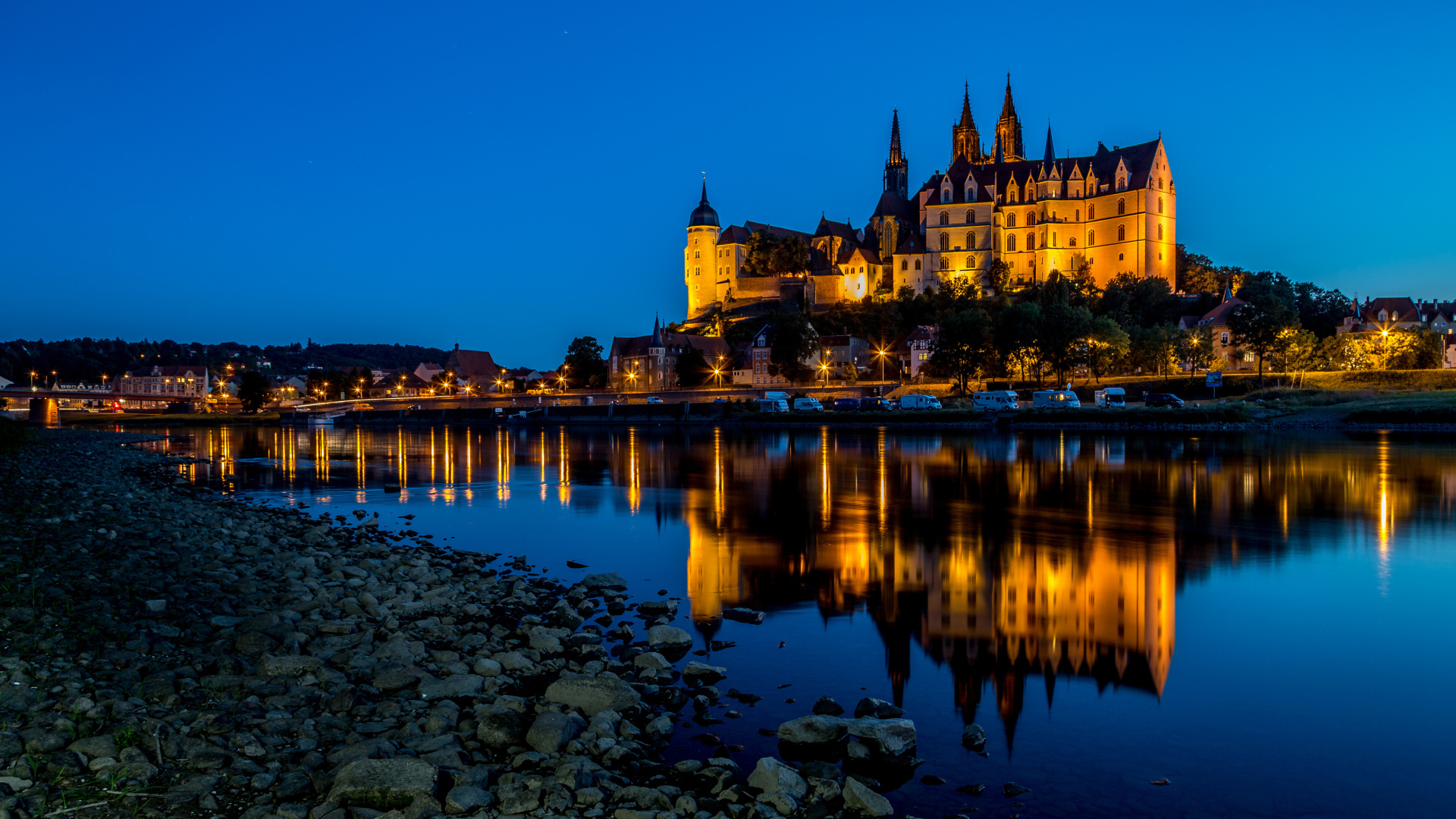 Evening lights of the castle of Albrechtsburg are reflected in the water, the city of Meissen, Germany