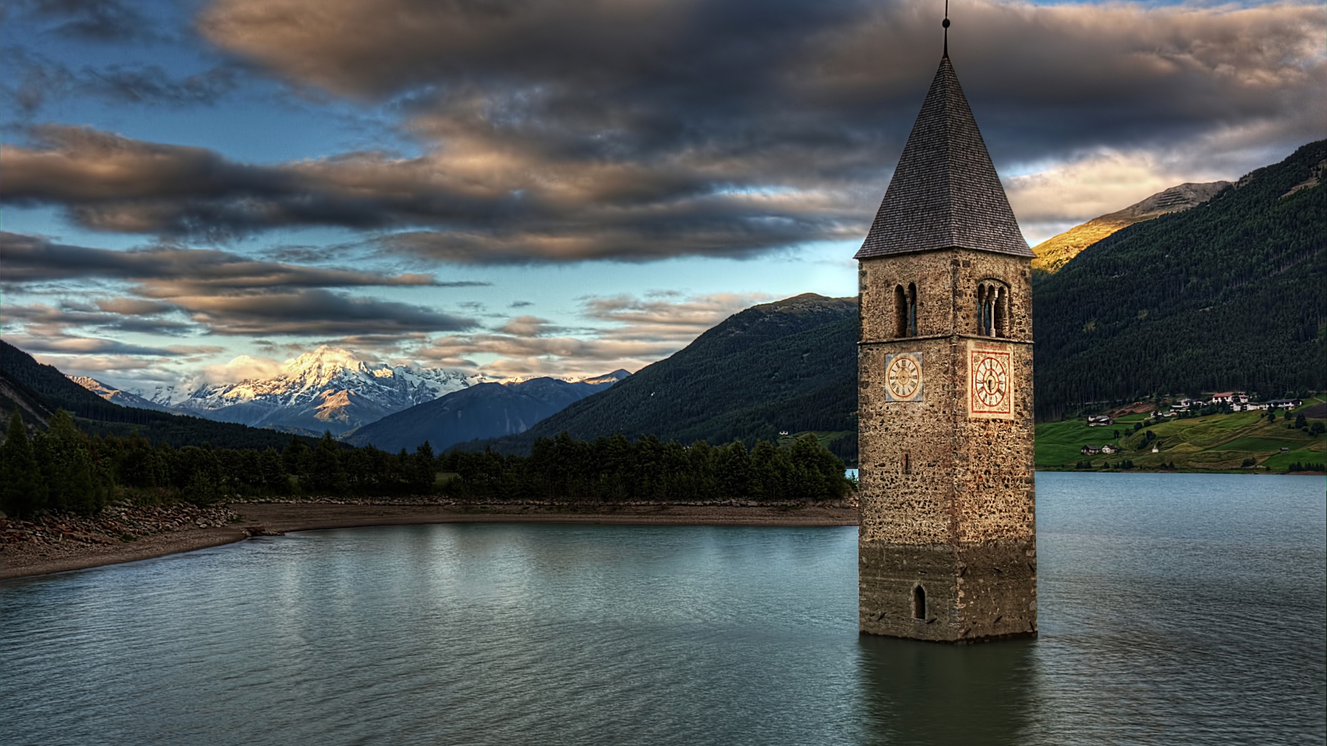Старинная часовня на фоне красивого неба посреди озера Резия, Италия