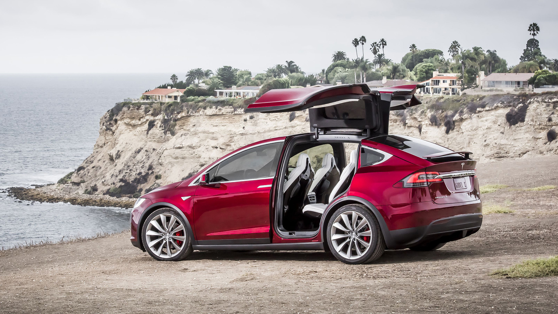 Красный электромобиль Тесла на берегу 
