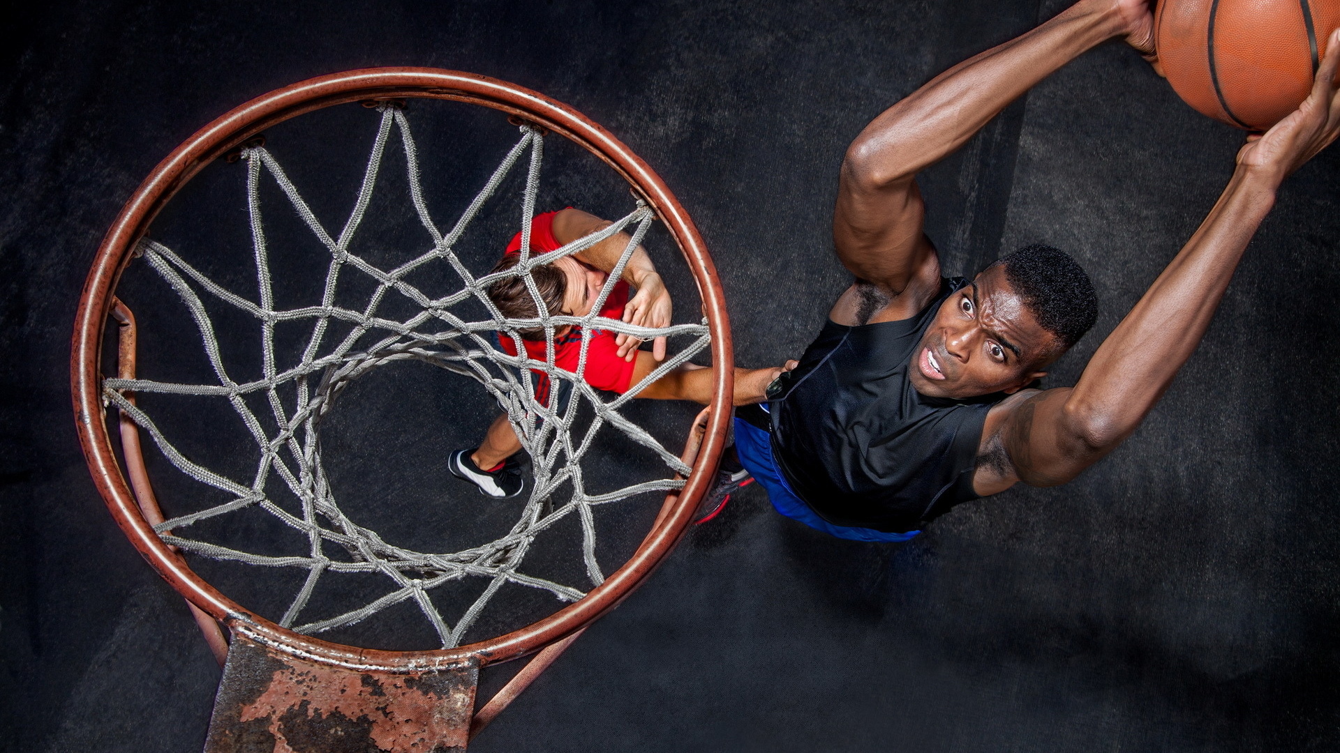 Баскетболист забрасывает мяч в кольцо 