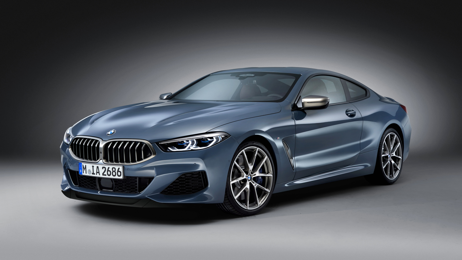 Серебристый автомобиль BMW M850i, 2018 на сером фоне