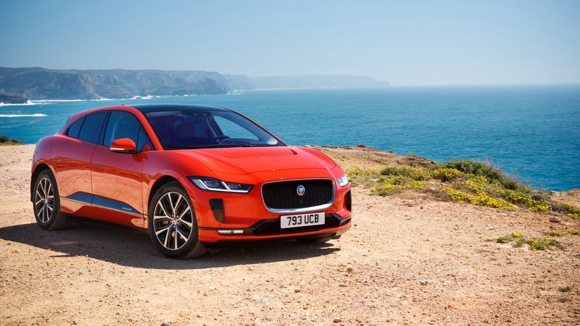 Red Jaguar I-Pace EV400 AWD HSE First Edition 2018 on the background of the ocean