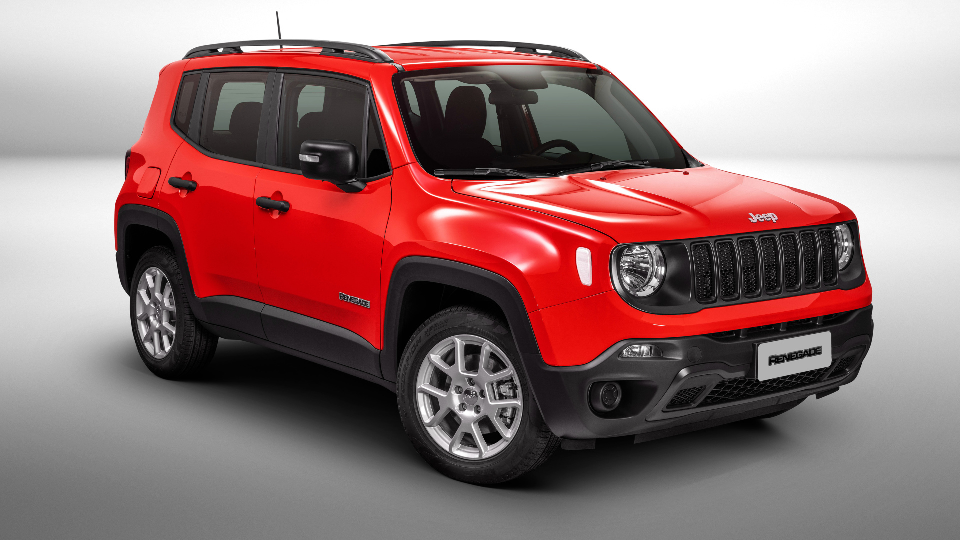 Красный автомобиль Jeep Renegade Sport на сером фоне