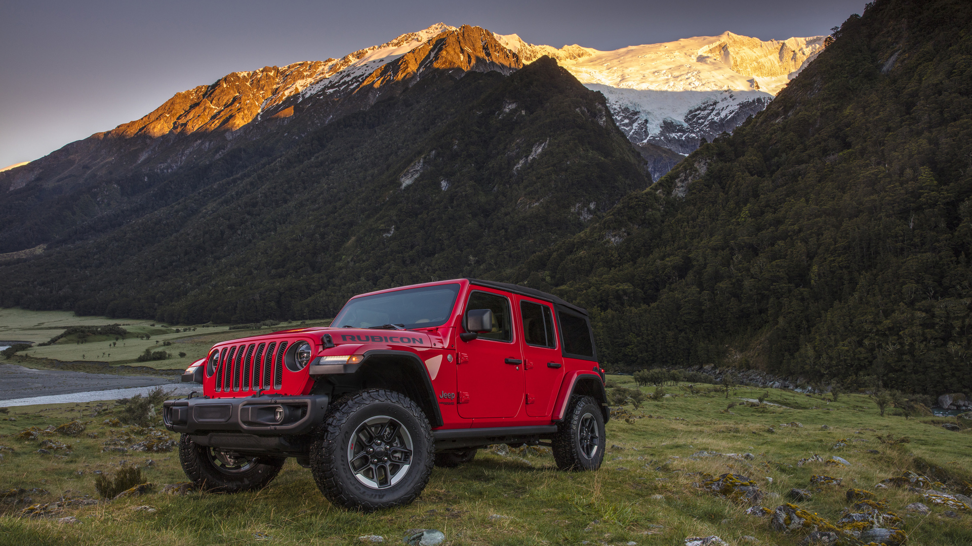 Красный автомобиль Jeep Wrangler на фоне гор
