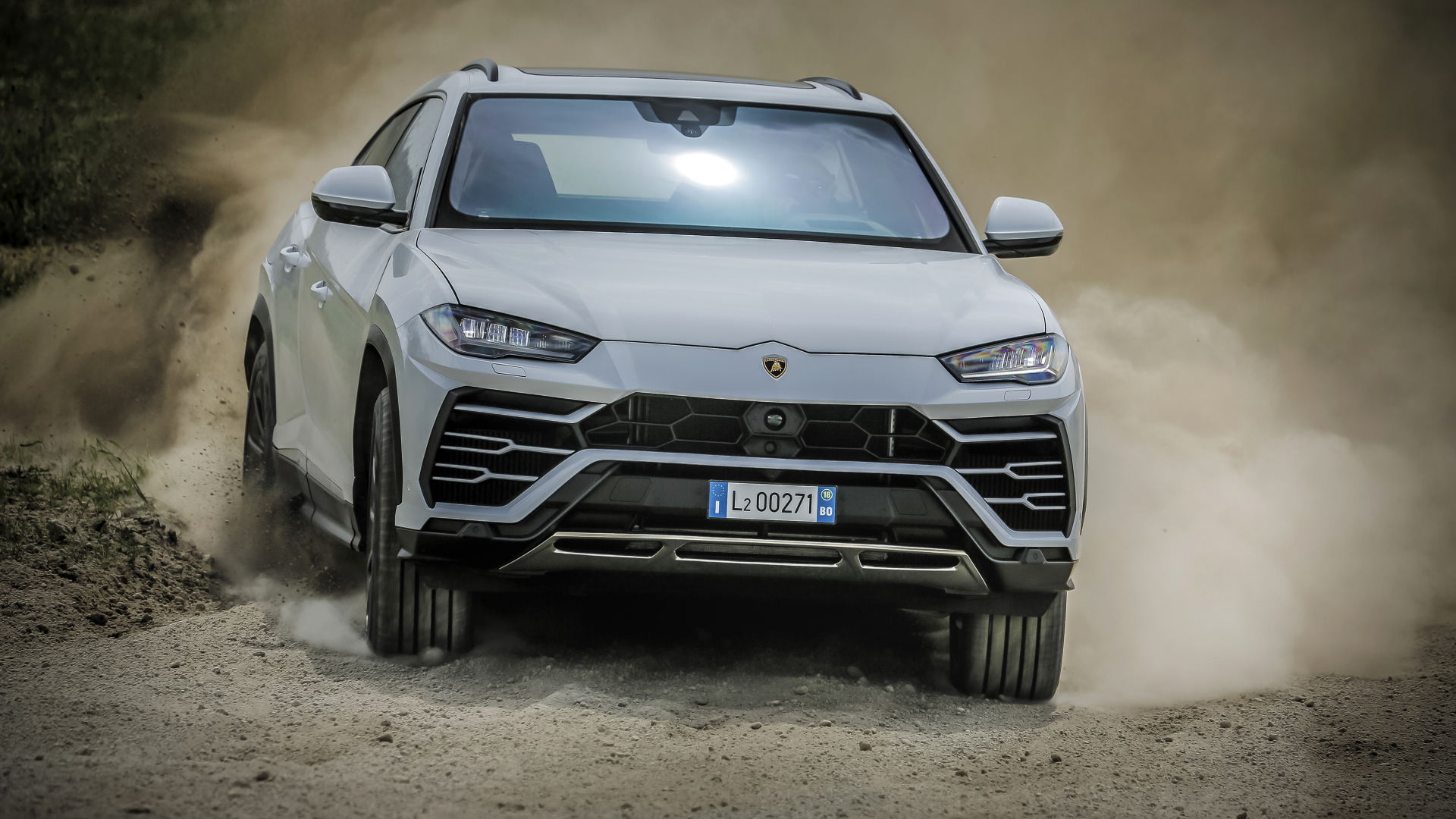 Белый автомобиль Lamborghini Urus  2018 года едет по дороге 