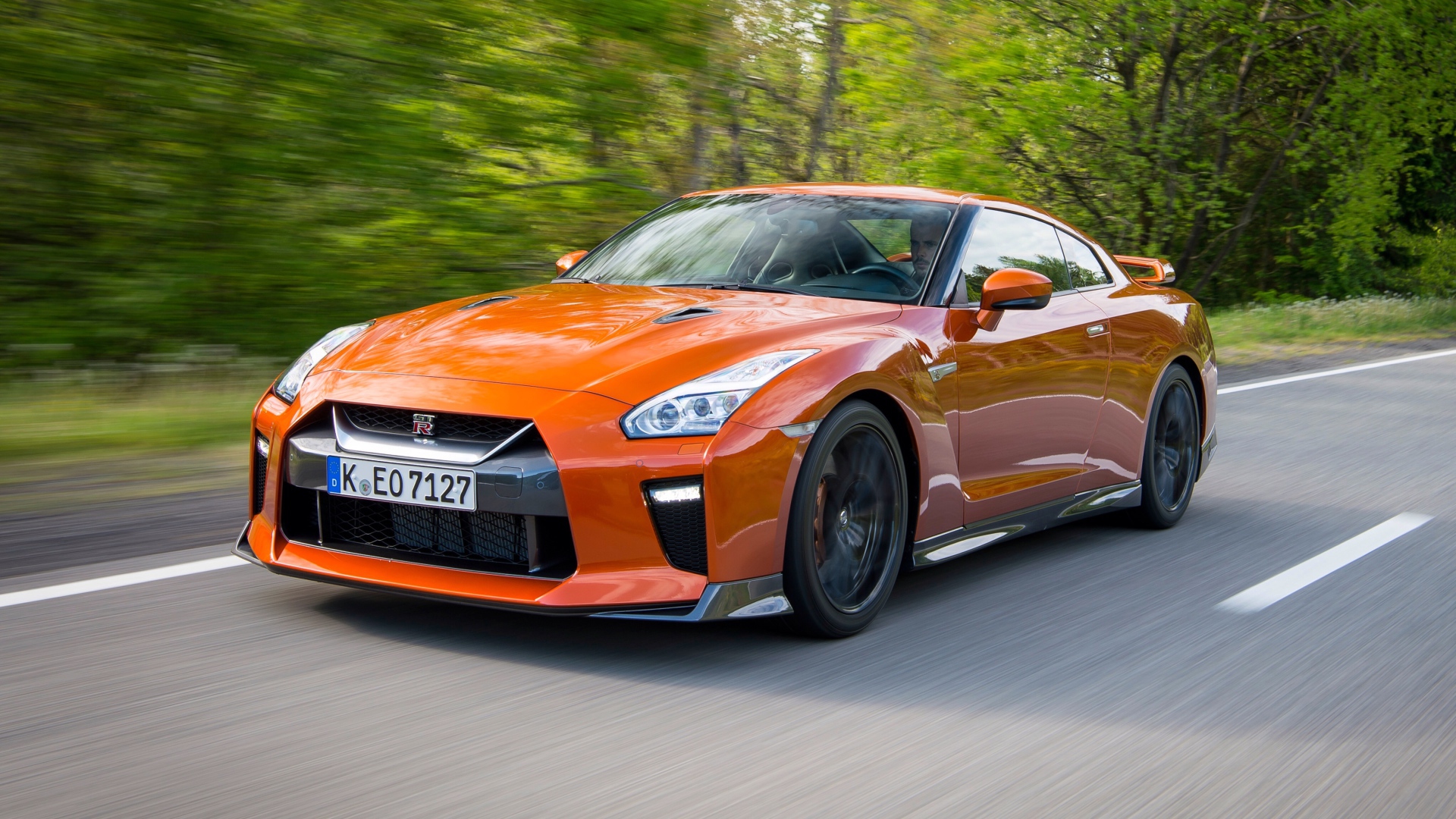 Оранжевый автомобиль Nissan GT-R на трассе