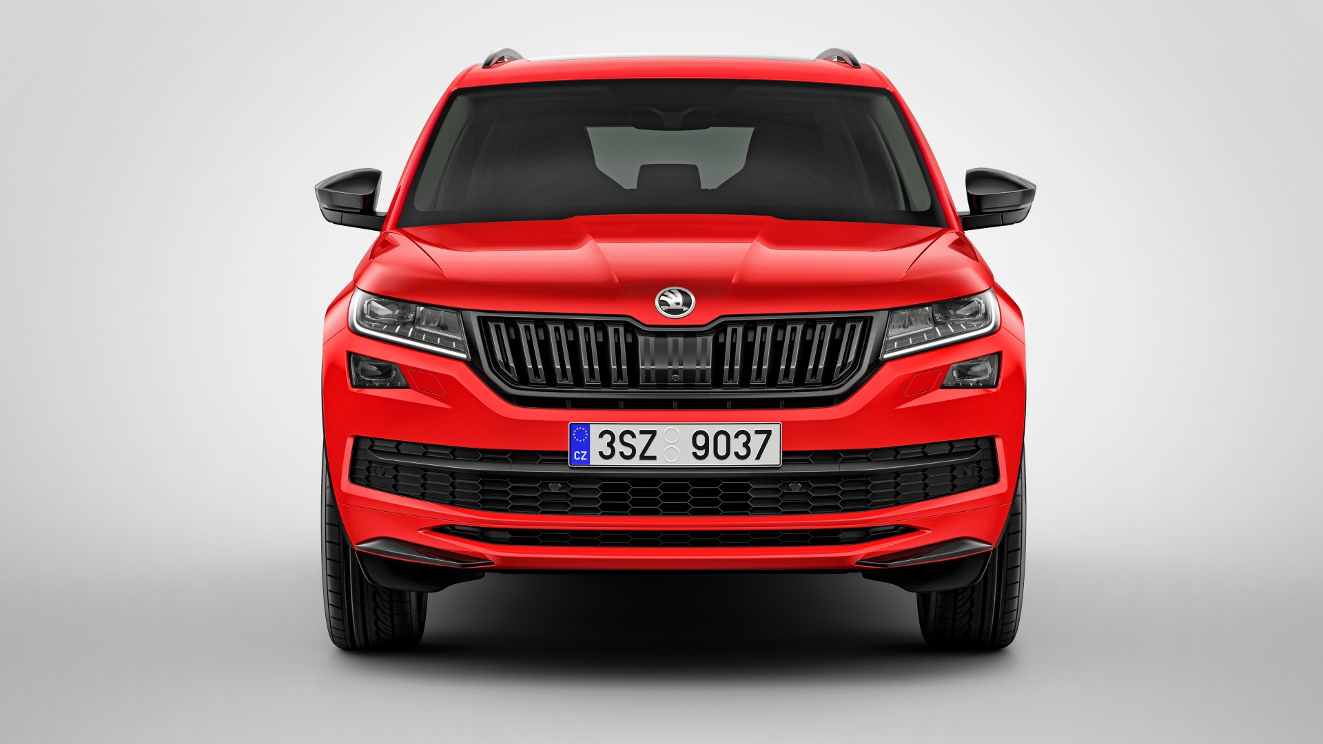 Красный автомобиль Skoda Kodiaq на сером фоне
